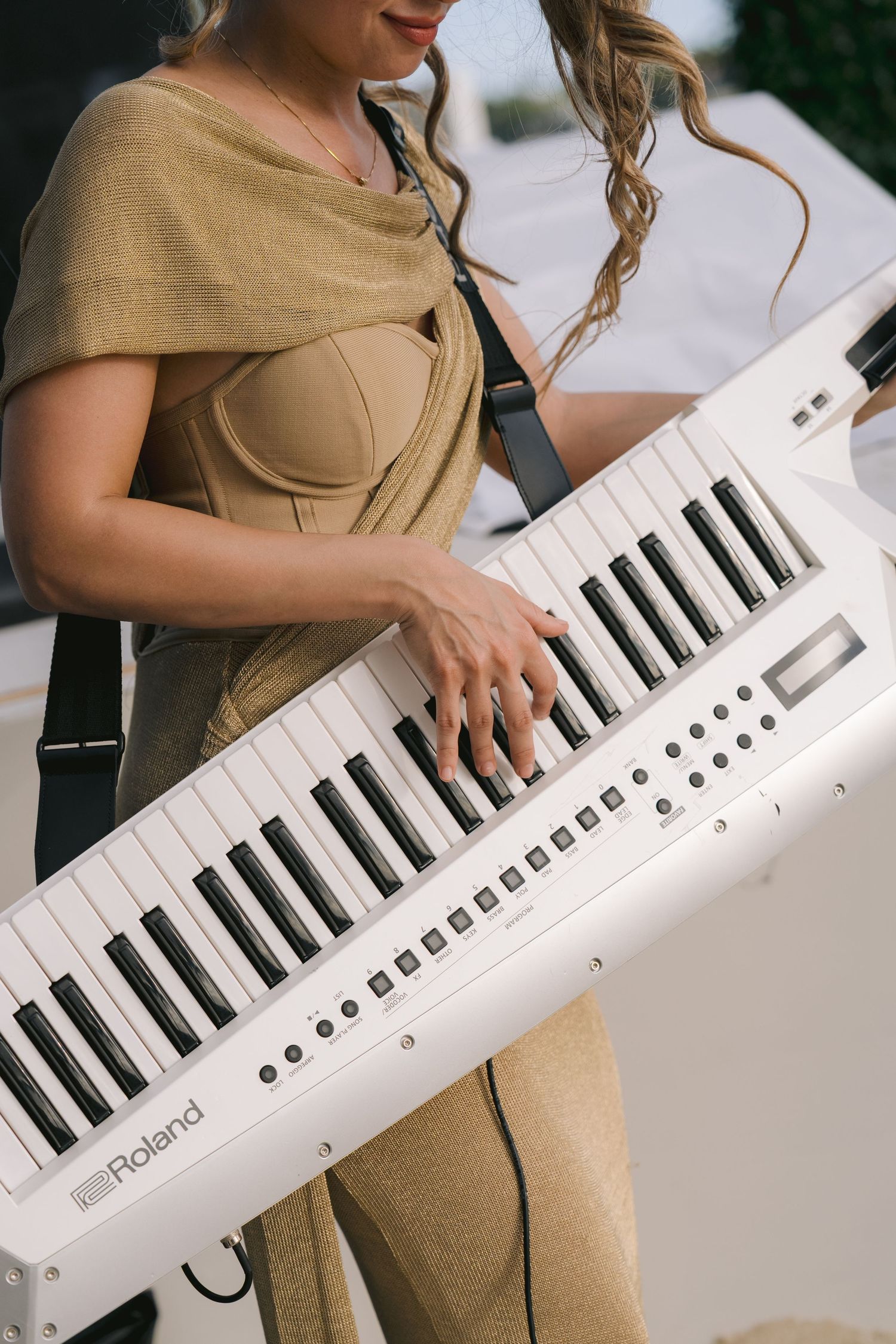 Close-up shots of hands playing a white MIDI keyboard controller against a blurred background.