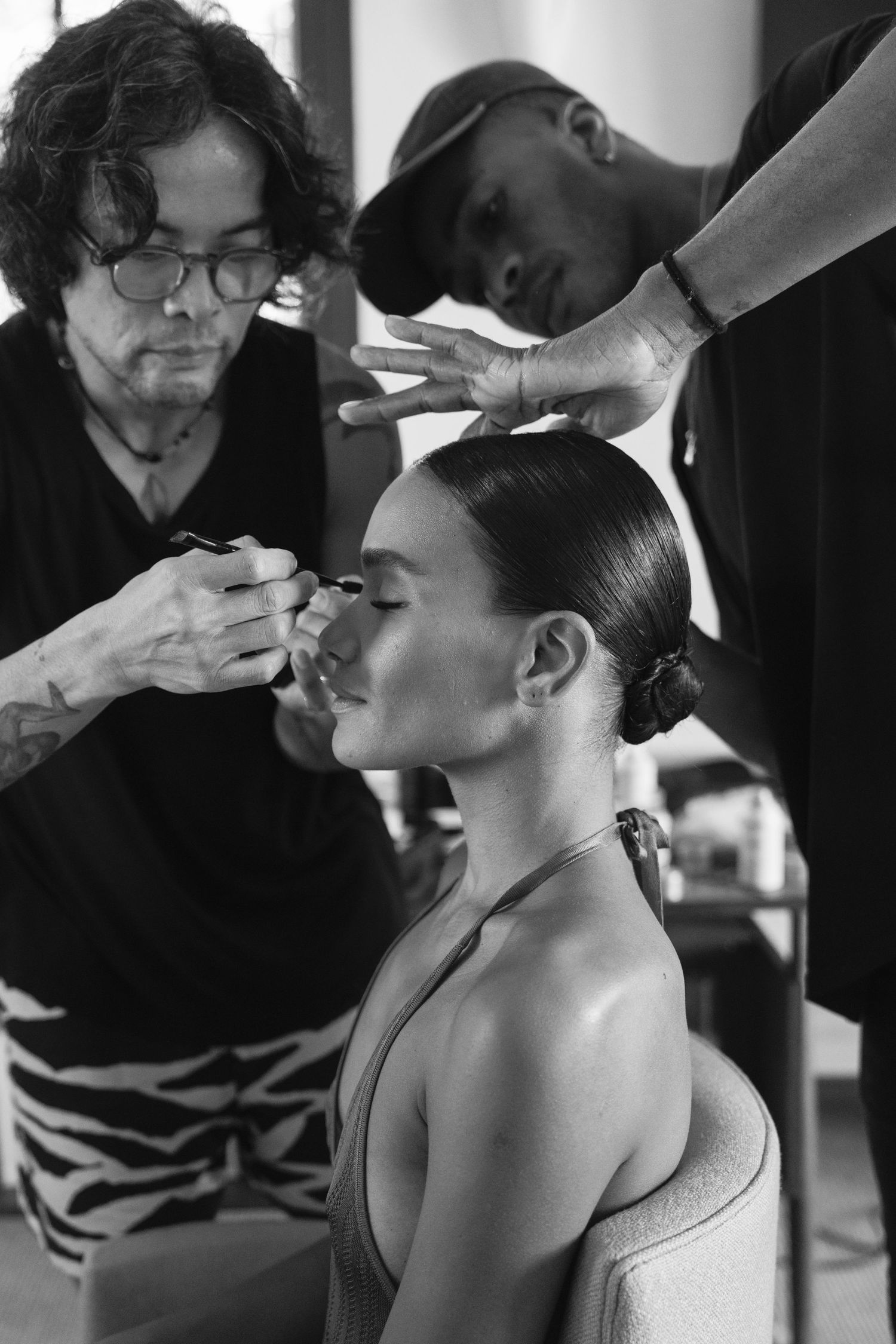 Behind the scenes sequence showing makeup application during a professional photoshoot preparation.