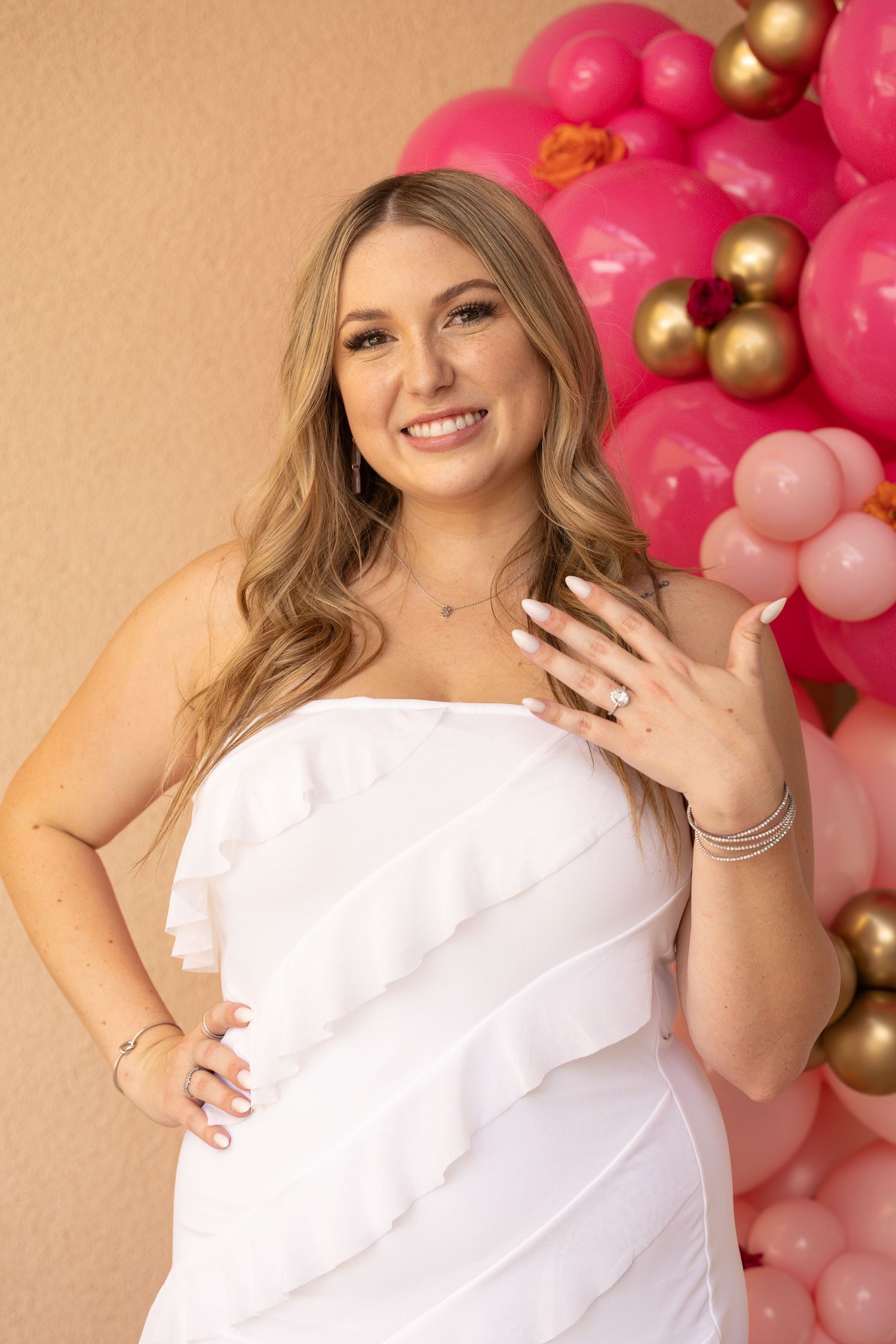 woman holding hand out in front of her showing off her engagement ring