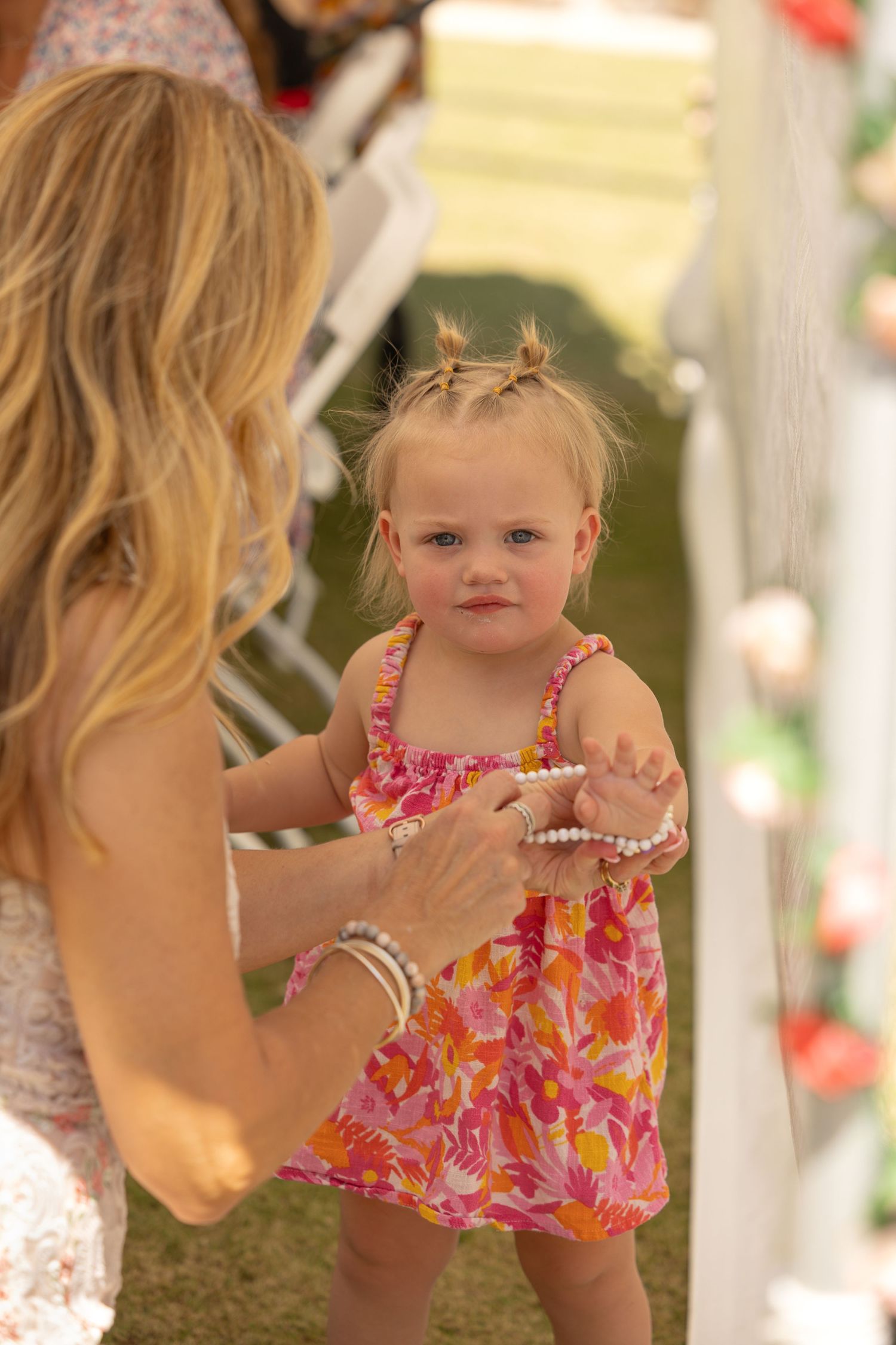 woman putting bracelet on toddler