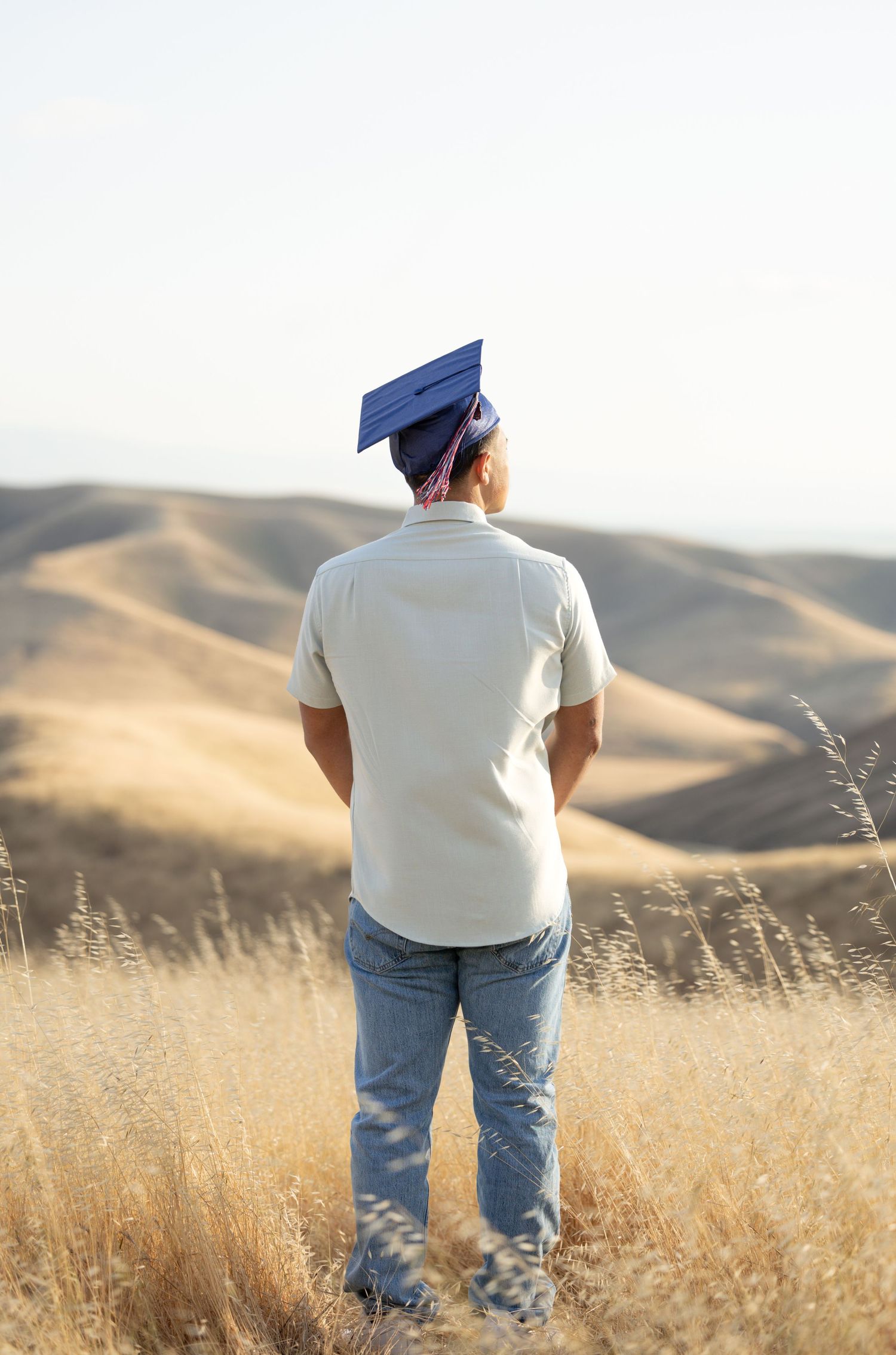 high school senior standing facing away with graduation cap on