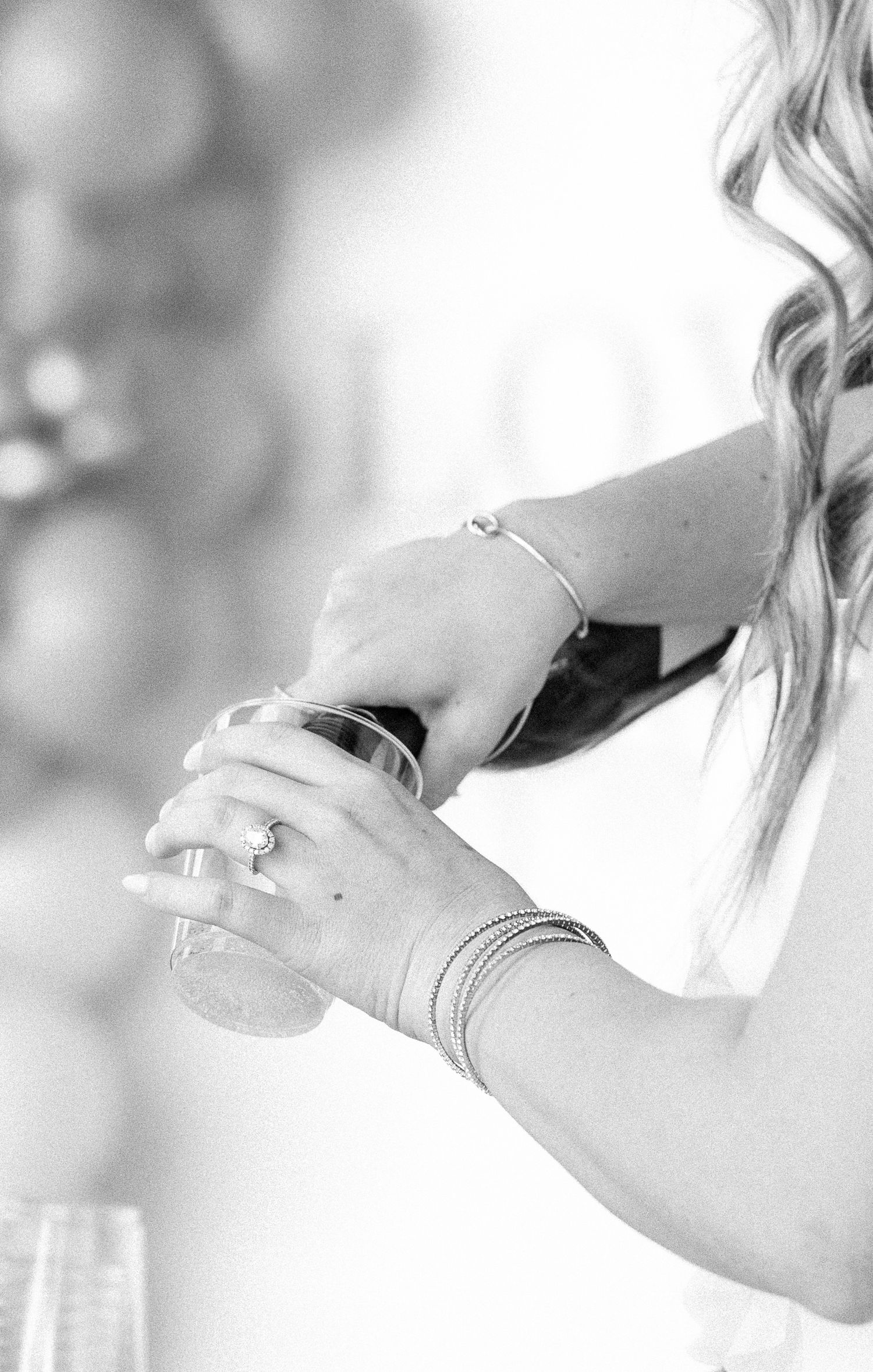 woman pouring champagne into cup in black and white