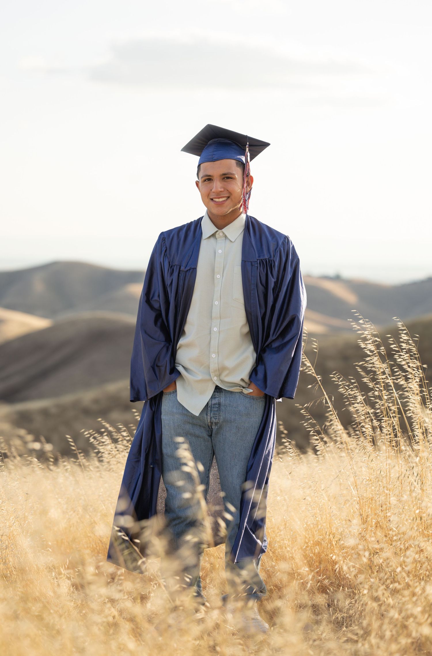 high school senior standing with graduation cap and gown on