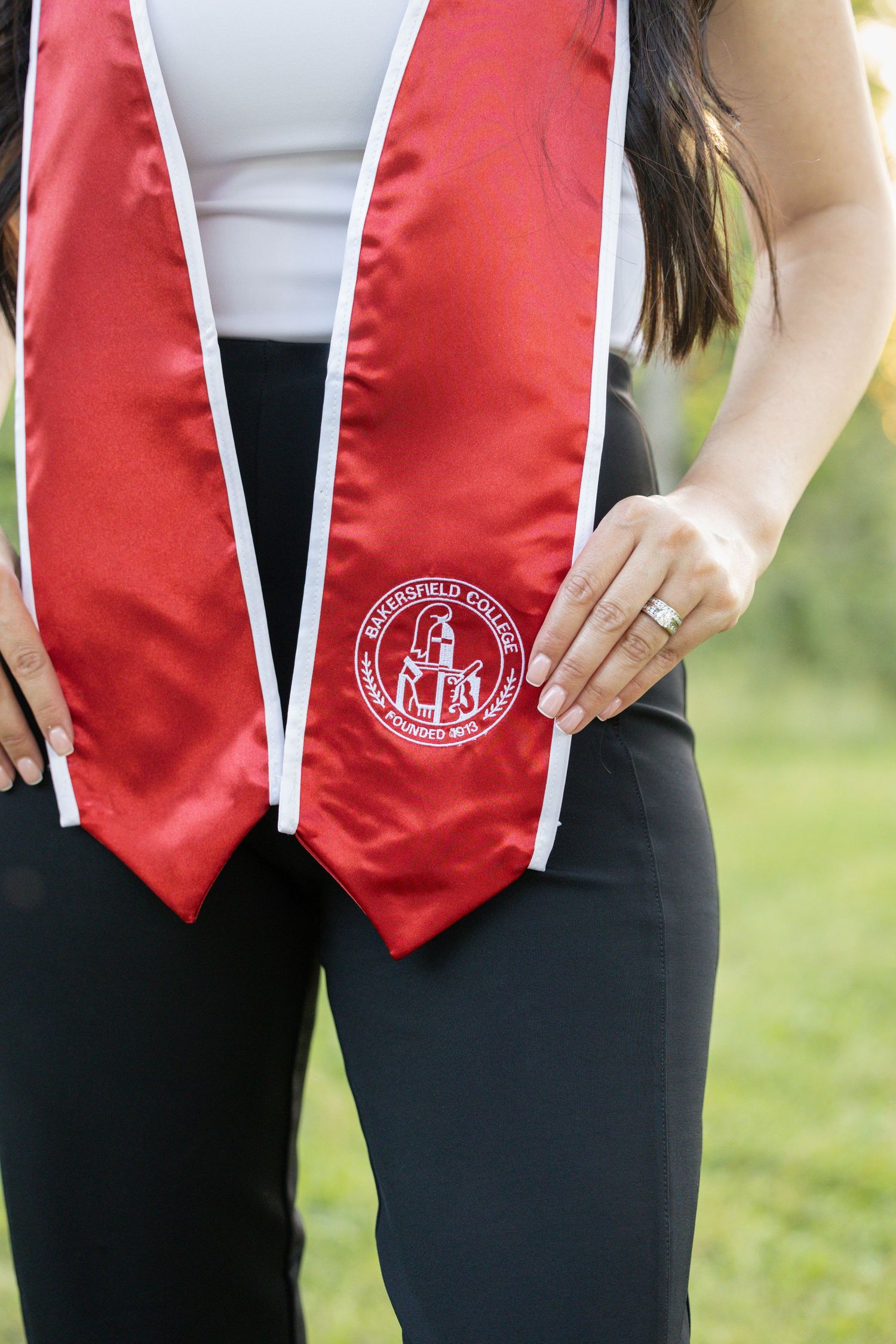 college senior holding graduation stole out in front of her