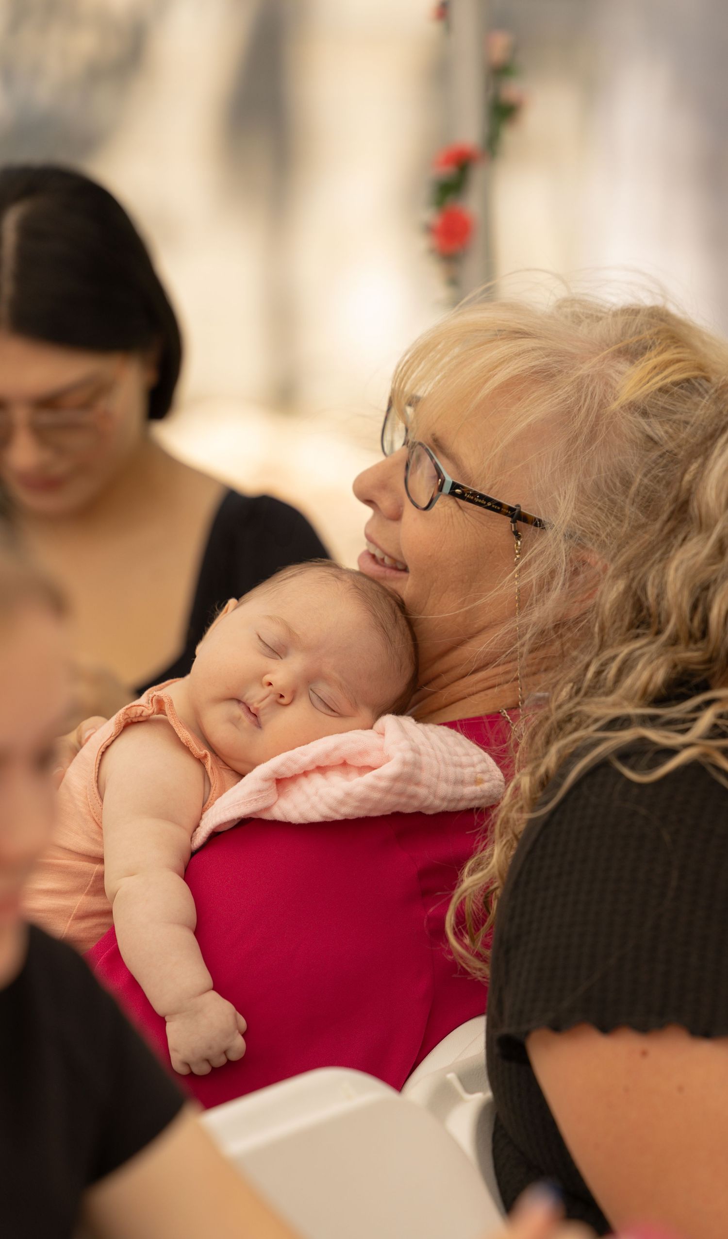 woman holding sleeping baby on her shoulder