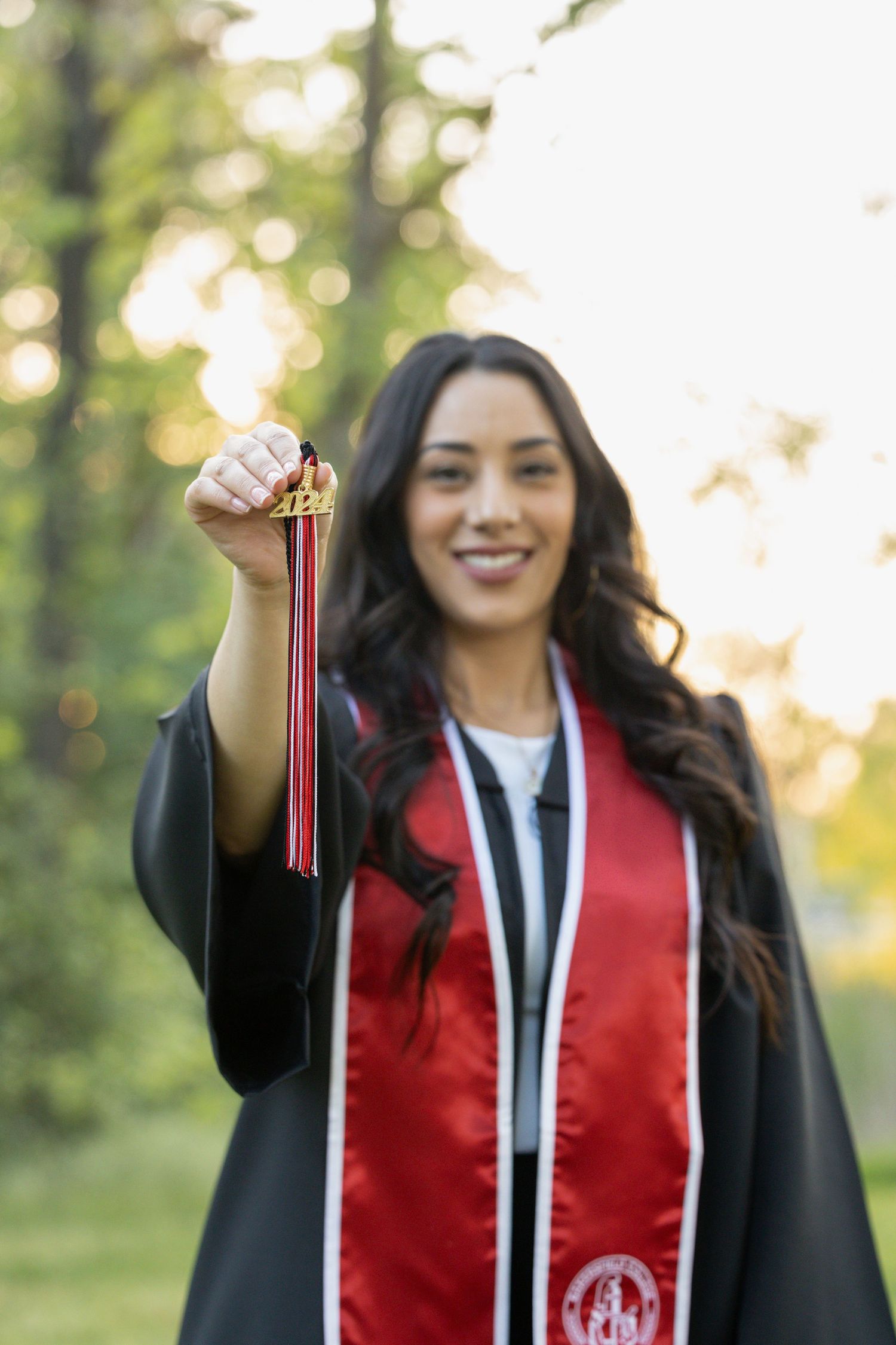 college senior holding tassel out in front of her