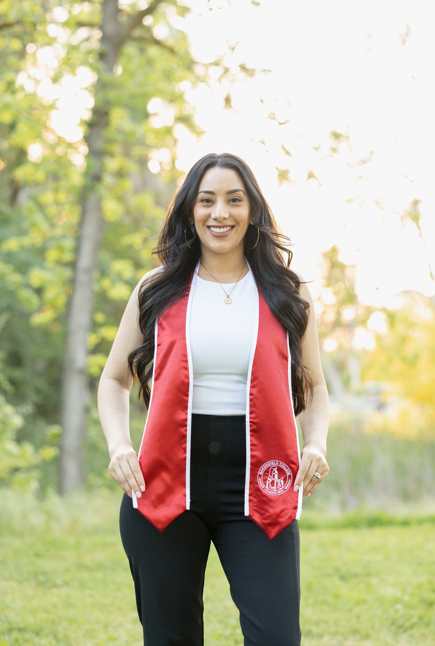 college senior holding graduation stole out in front of her