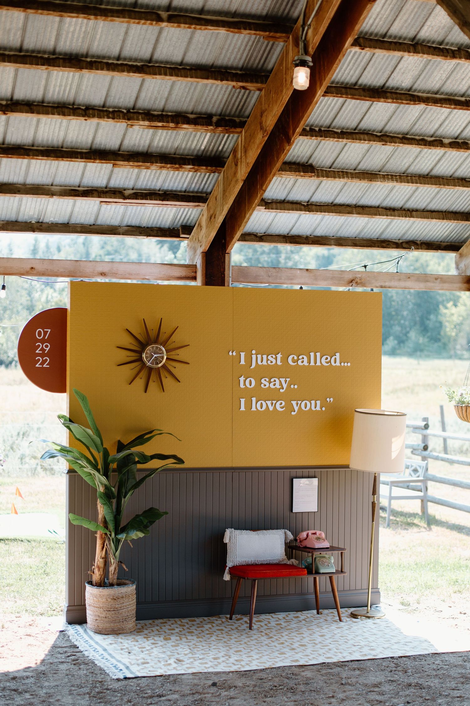A rustic covered outdoor venue with brown walls displays a romantic quote 'I just called to say I love you' on the wall.