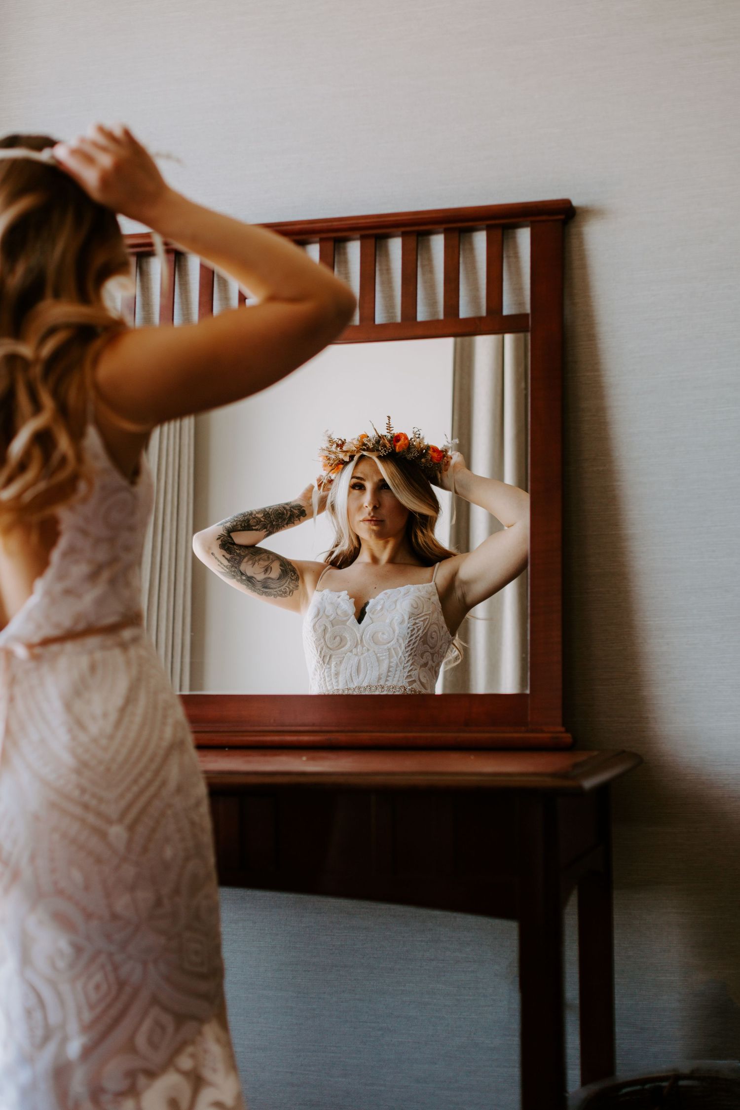 A series of photos showing someone in a white lace dress adjusting their hair while looking in a wooden framed mirror.