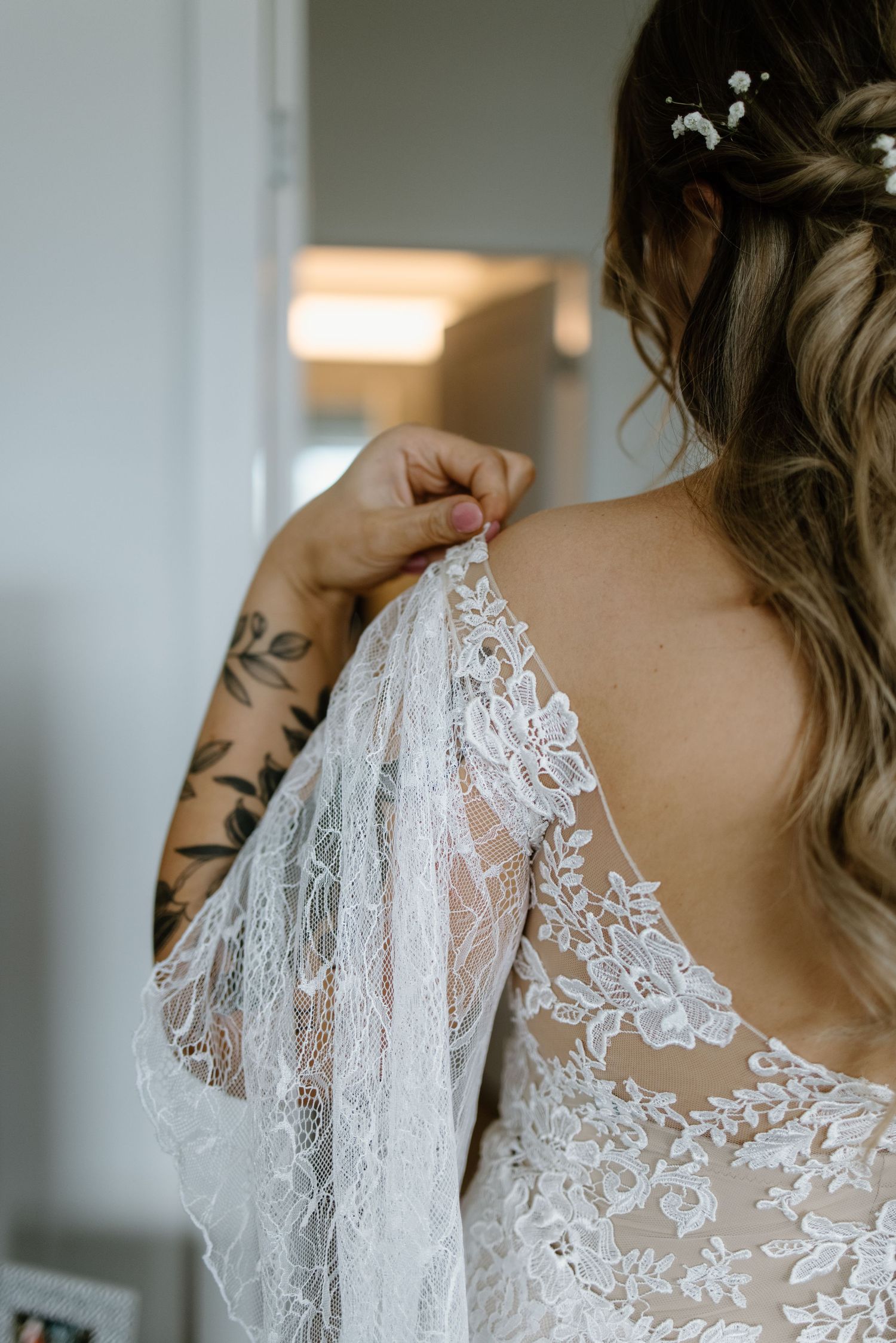 Delicate white lace detail on the back of a wedding dress with intricate floral patterns.