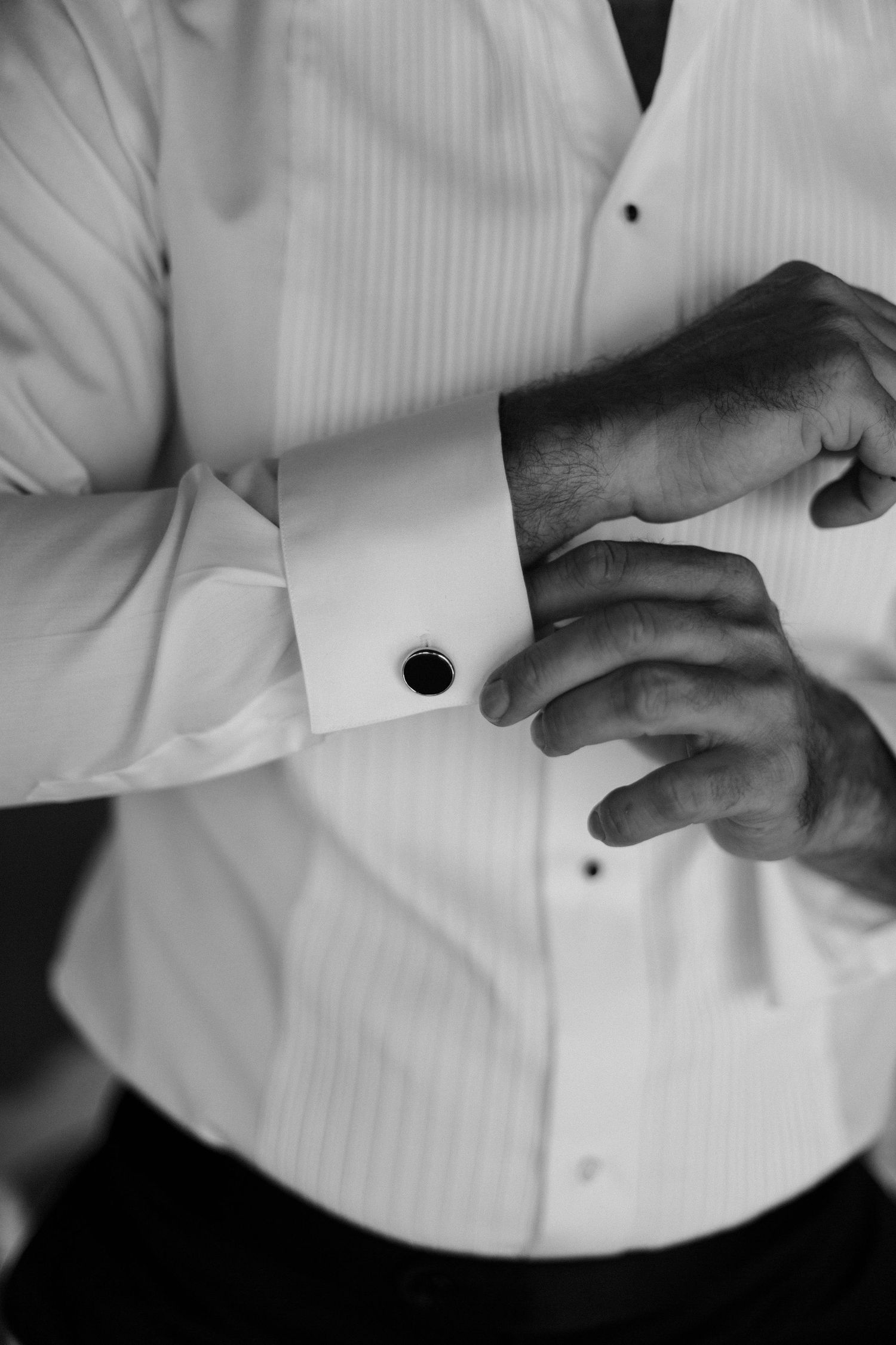 A sequence of black and white images showing hands punching holes in a white paper or card.