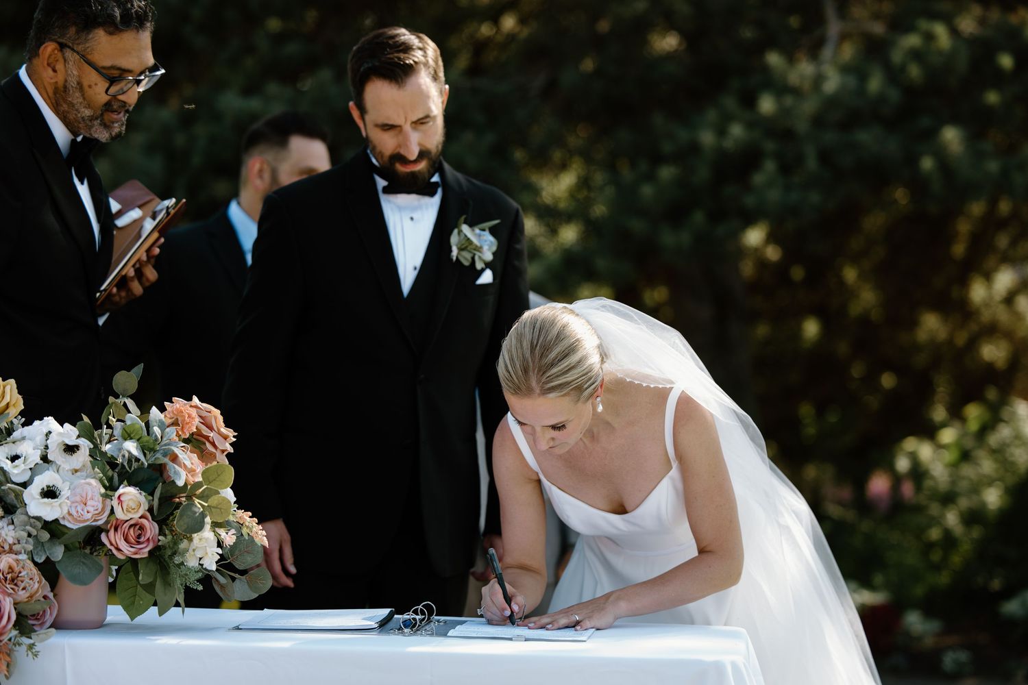 Wedding ceremony signing moment captured in bright natural lighting.