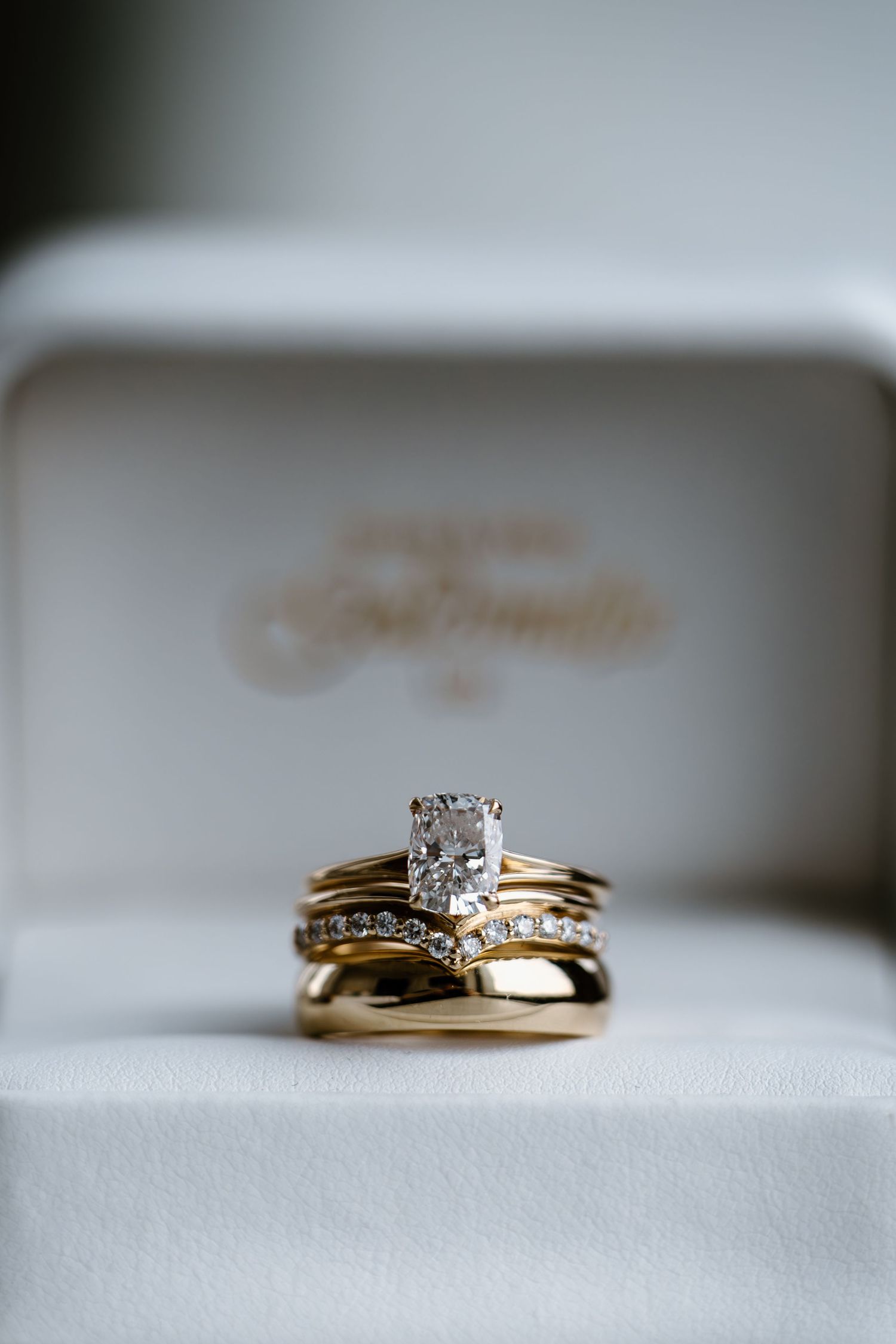 A close-up sequence of a gold wedding ring set with diamonds shown from different angles on a white surface.