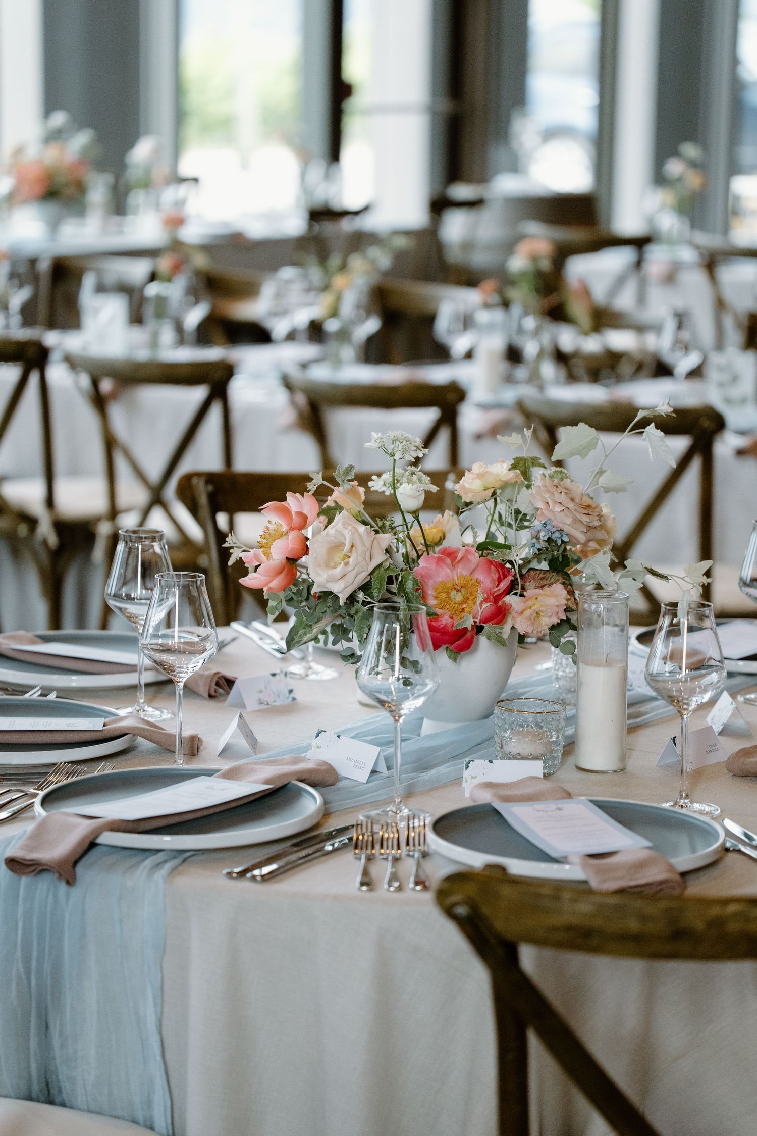 Elegant wedding table decor featuring pink and white floral arrangements with light blue table runners.
