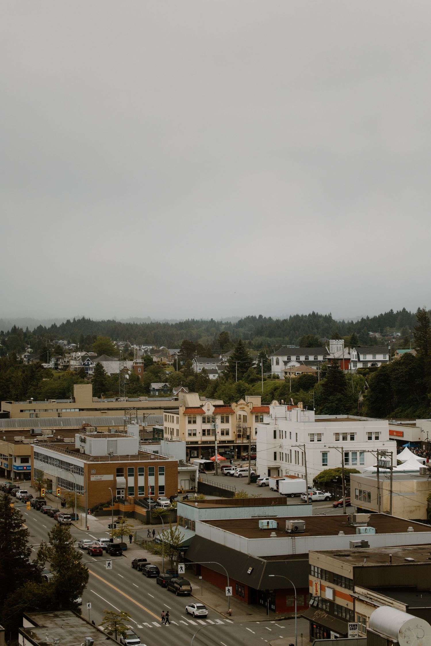 Aerial view of small town buildings and streets on overcast day.