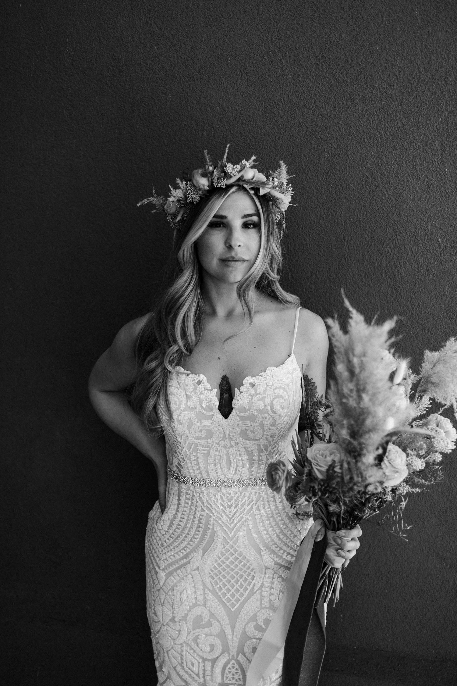 Black and white detail shot of intricate lace wedding dress with delicate pattern work.