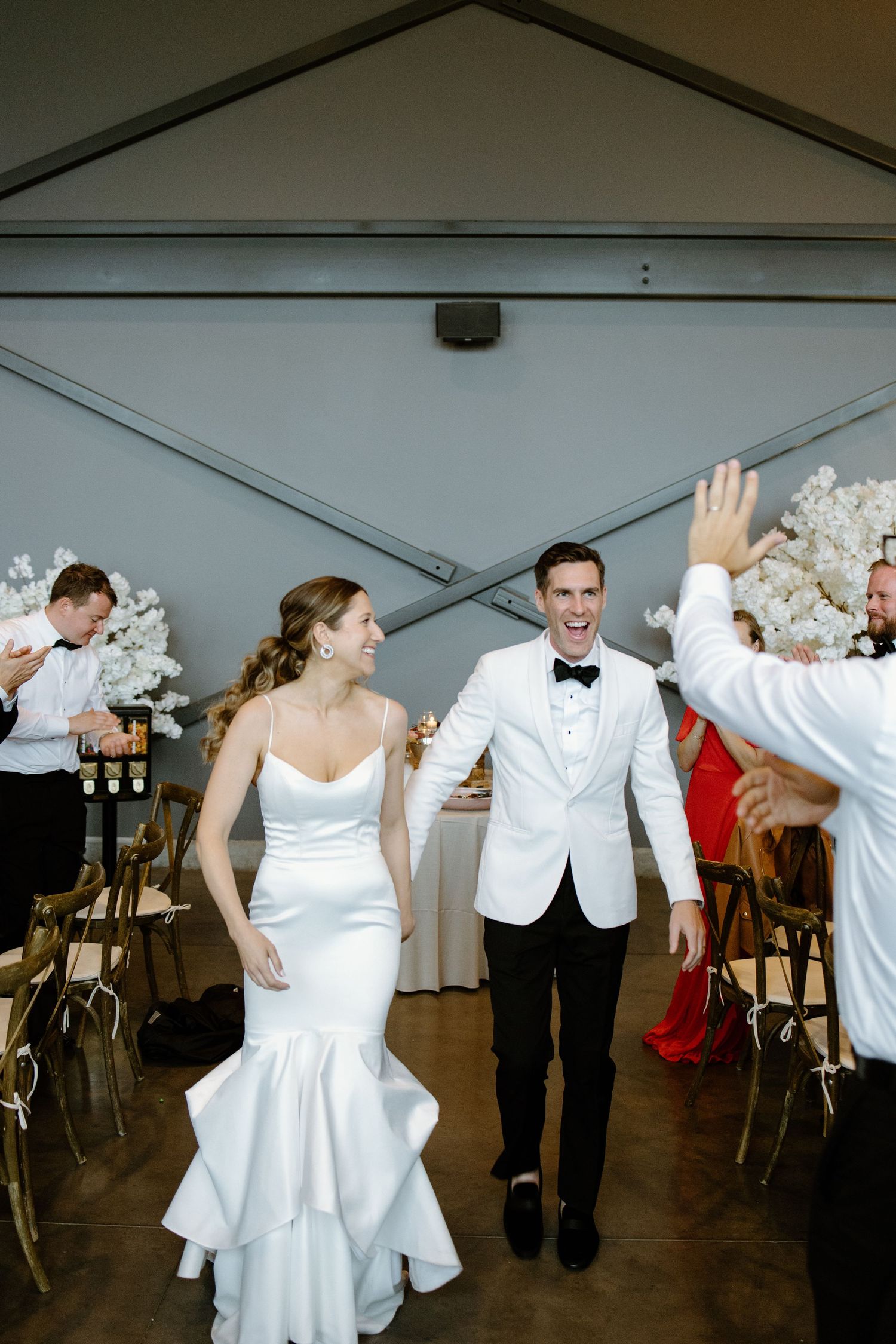 Wedding celebration with dancing and joyful moments in a modern reception venue.