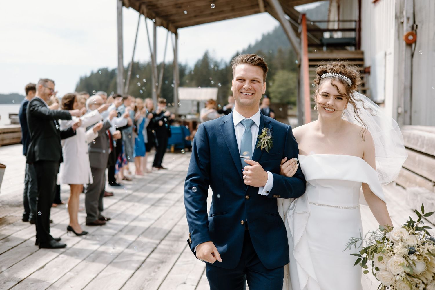 Wedding celebration on wooden deck overlooking waterfront.