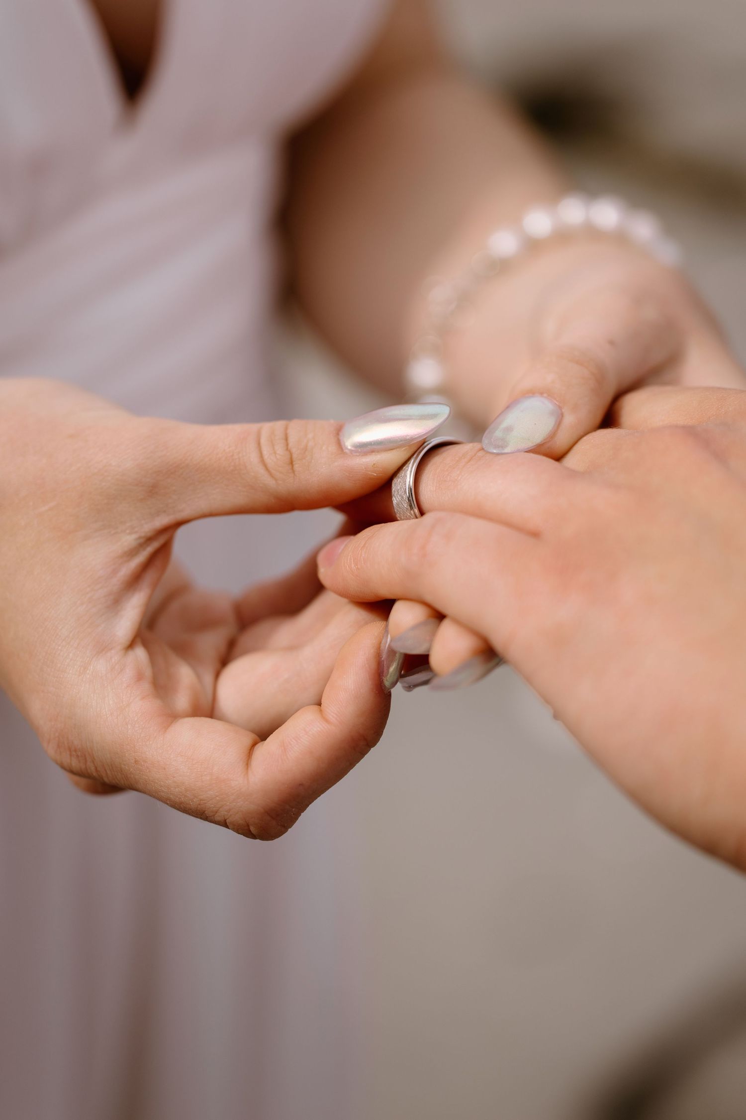 Close-up sequence of hands exchanging wedding rings during an intimate ceremony.