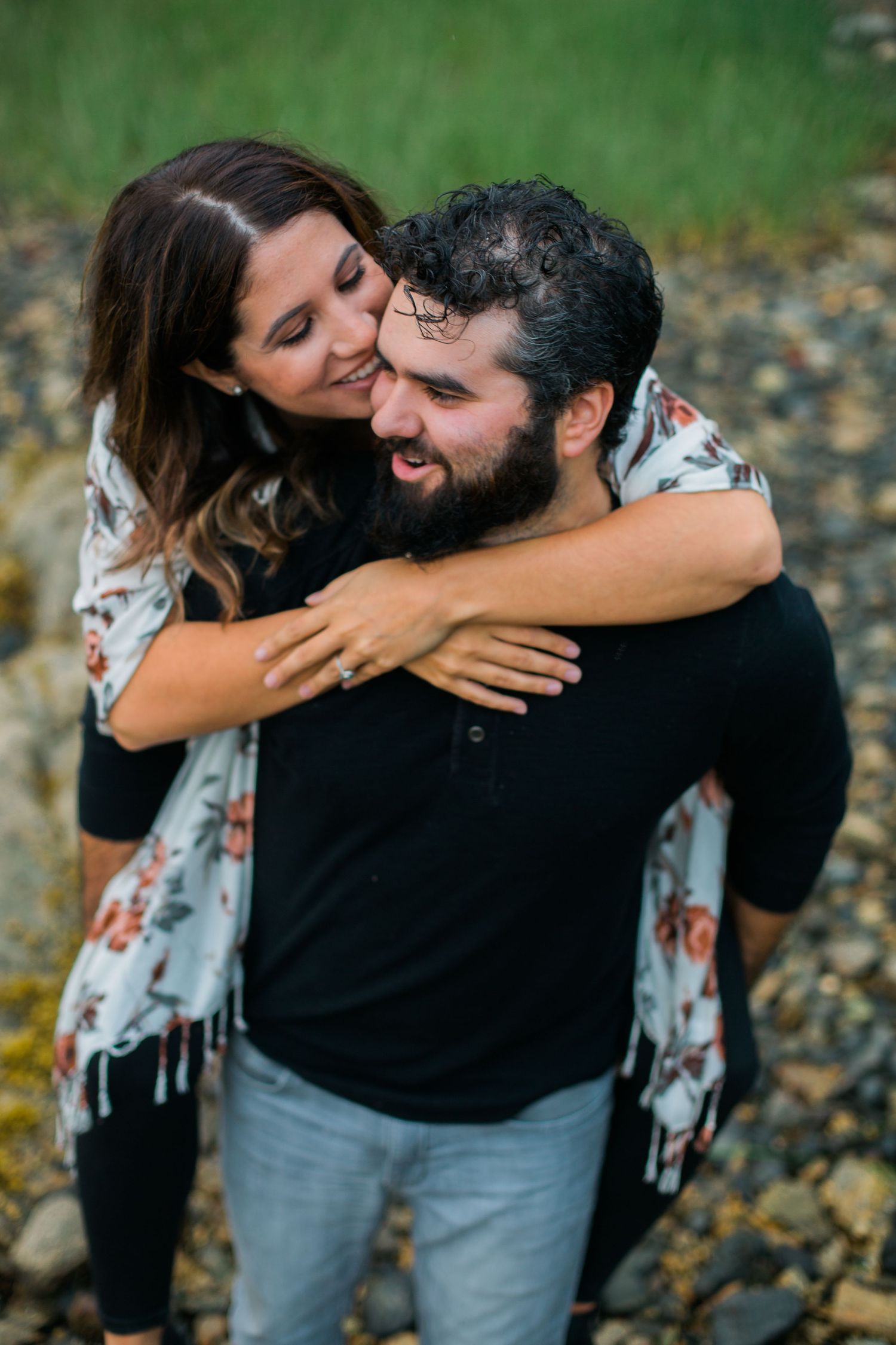 A couple sharing intimate embraces in a natural outdoor setting with green foliage.