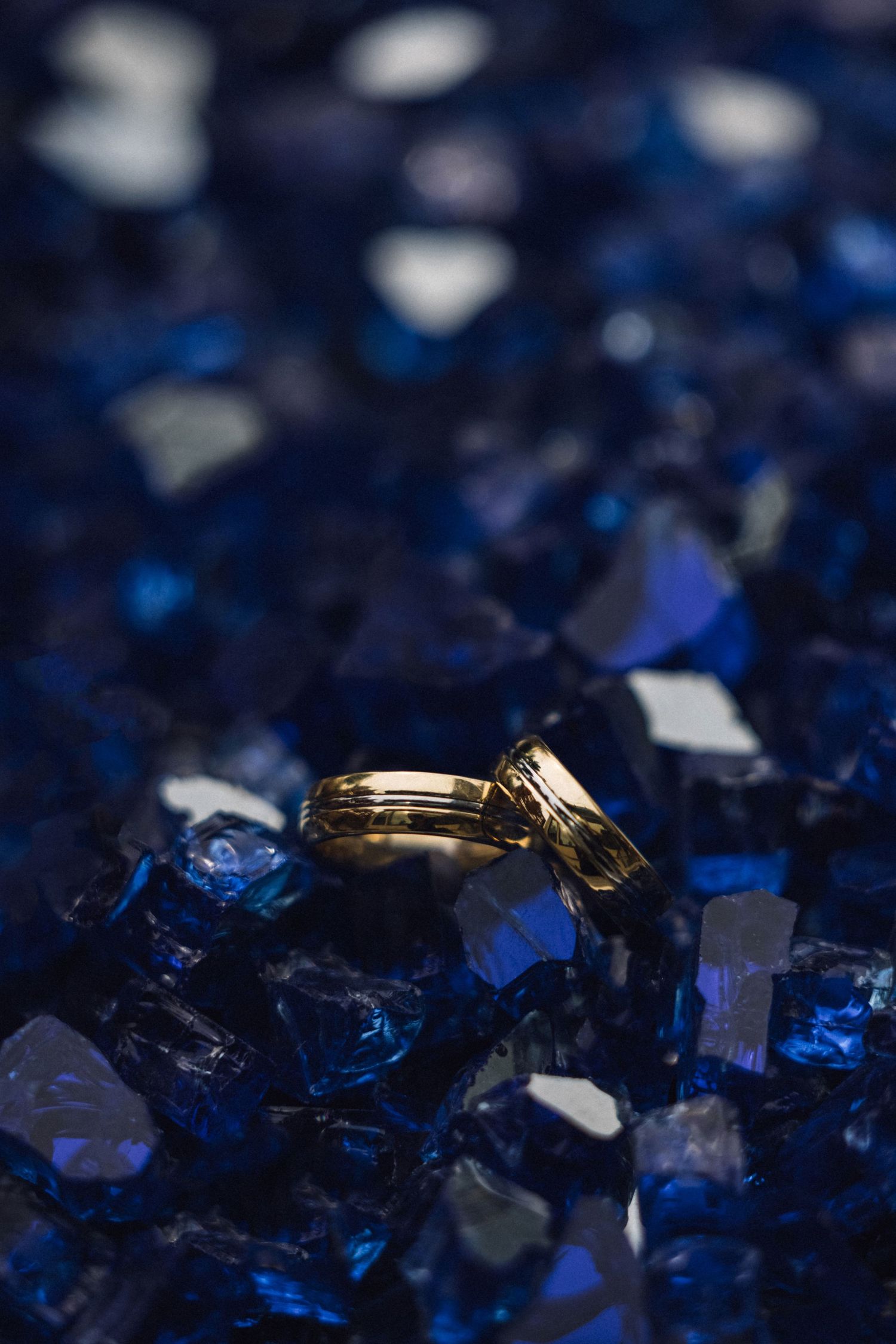 Close-up macro shot of deep blue crystal formations with metallic gold accents against a dark background.