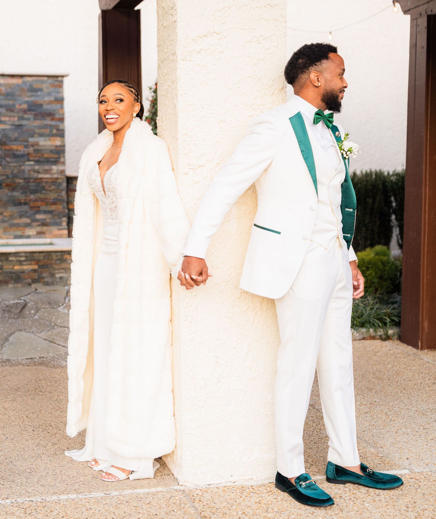 A couple in matching white outfits poses together, with one wearing distinctive teal shoes.
