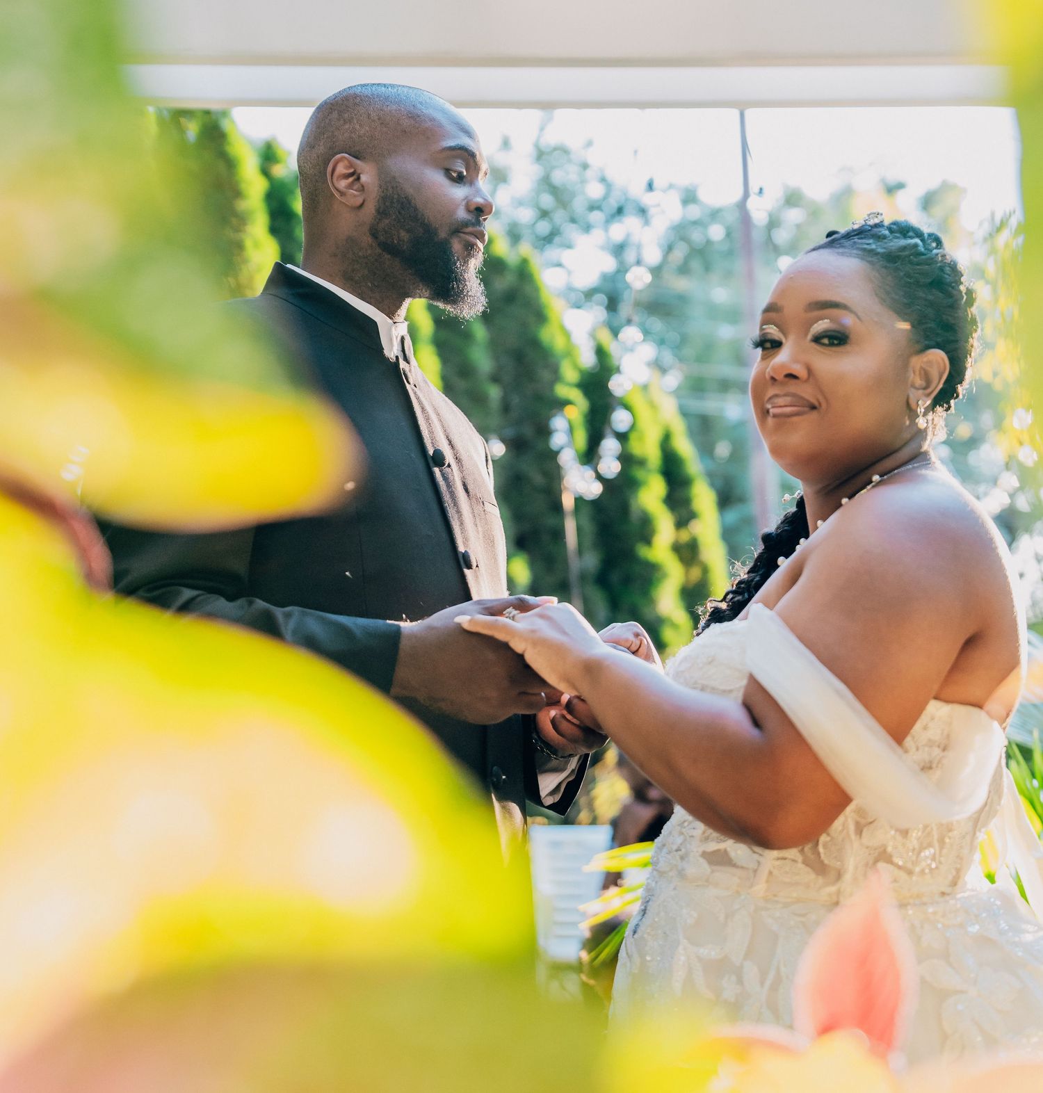 A couple shares a tender moment during their outdoor wedding celebration in natural lighting.