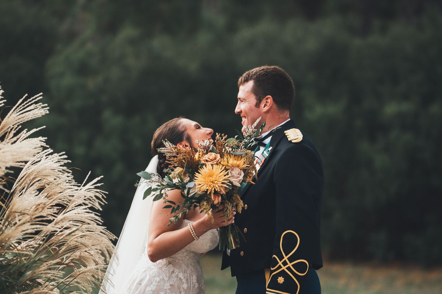 Intimate wedding couple poses in natural garden setting with sunflowers and pampas grass.