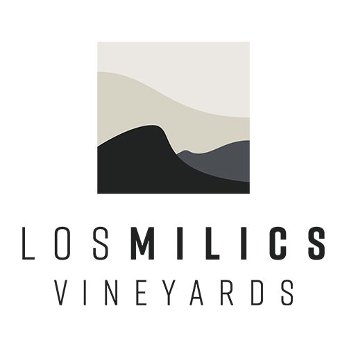 Los Milics Vineyards logo featuring abstract mountain landscape layers in black and beige tones above bold serif text.