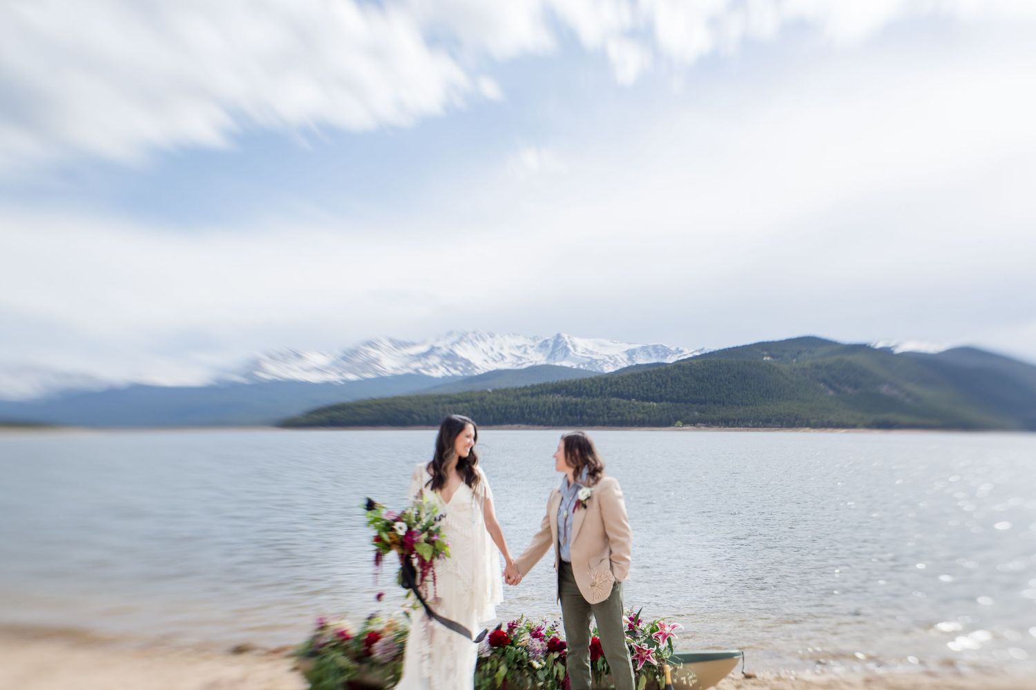 A scenic mountain lake view with snow-capped peaks and green hills in the background.