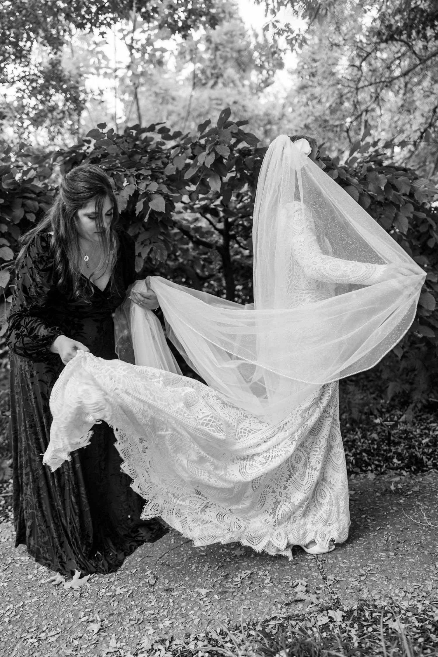 A series of black and white photographs showing a flowing white wedding dress and veil being arranged outdoors.