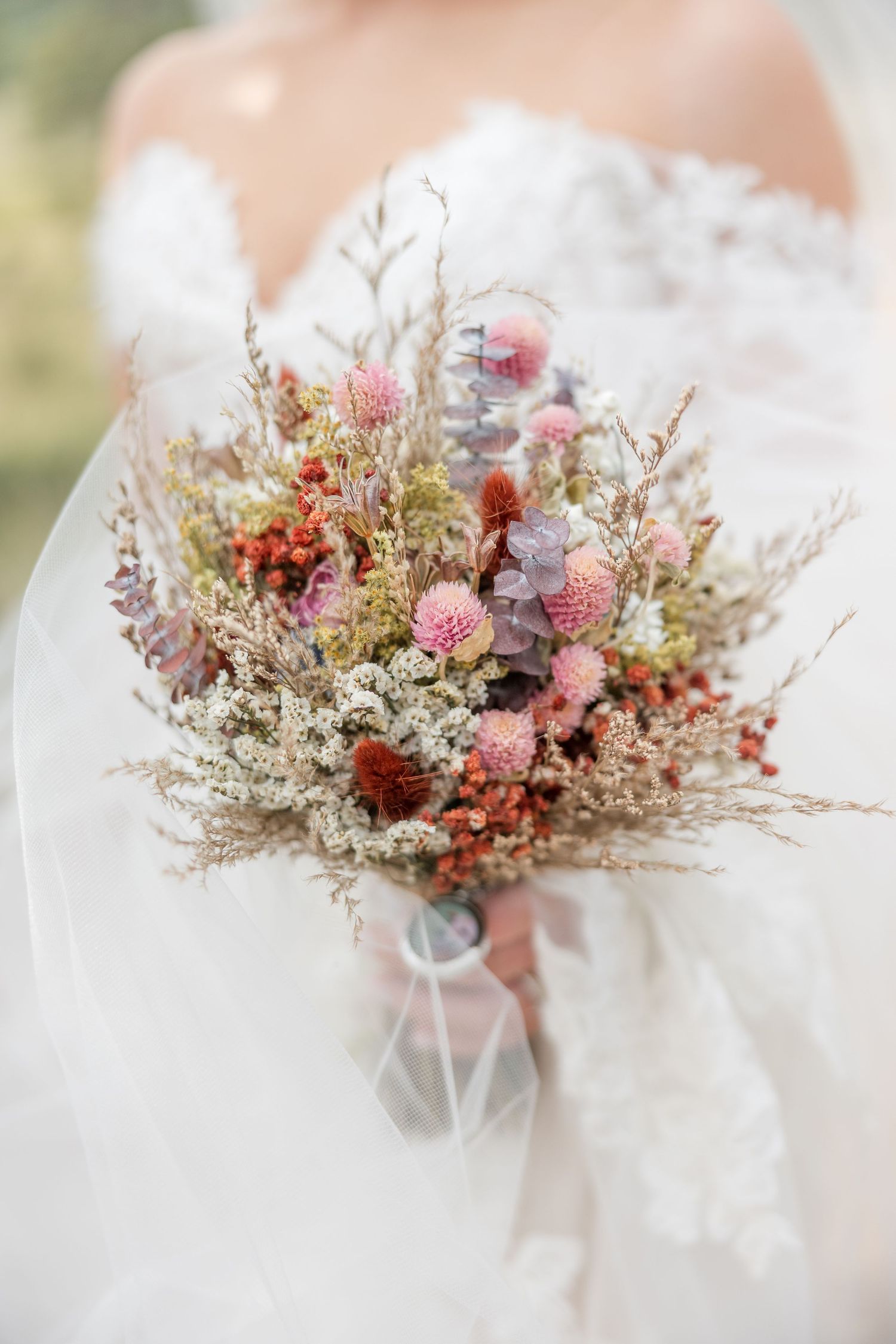 Delicate pink and white dried flower bouquet with textured foliage arranged in a romantic vintage style.