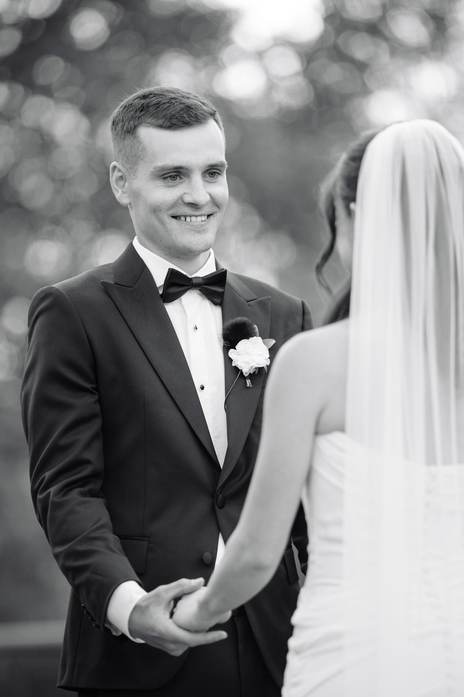 Black and white wedding photo sequence showing emotional first look reaction between couple in formal attire.