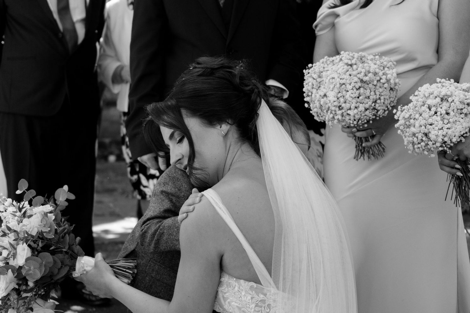 Bride sharing an emotional moment with a wedding guest during group photographs, captured by luxury wedding content creator Unveil by Hollie