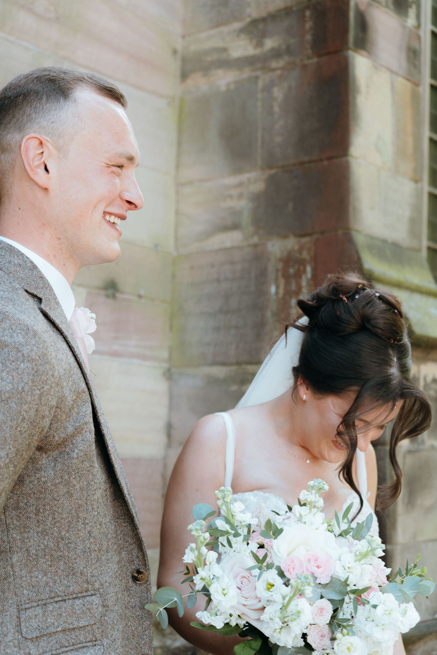 Bride and groom sharing a joyful wedding day moment outside the ceremony venue, captured by luxury wedding content creator Unveil by Hollie
