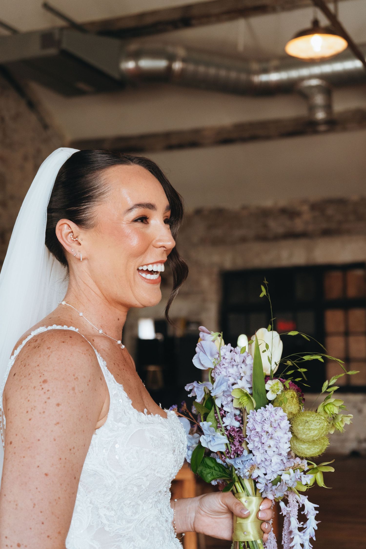 Bride smiling during her wedding day while holding a beautiful pastel bouquet, captured by luxury wedding content creator Unveil by Hollie
