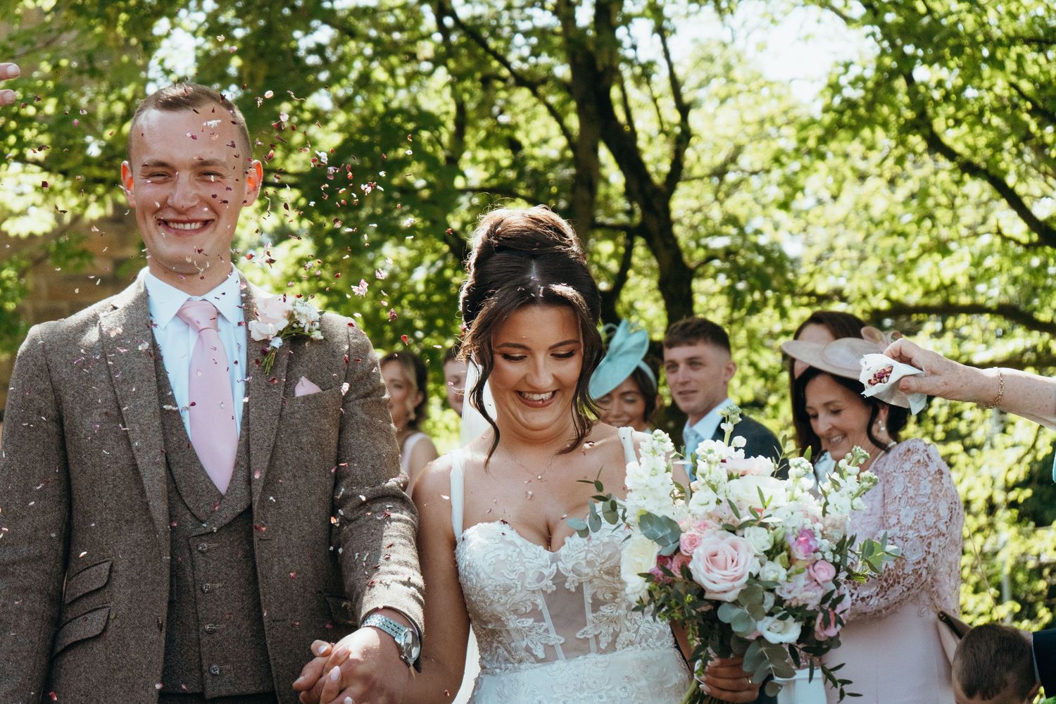 Newlyweds walking through a confetti celebration after their wedding ceremony, captured by luxury wedding content creator Unveil by Hollie