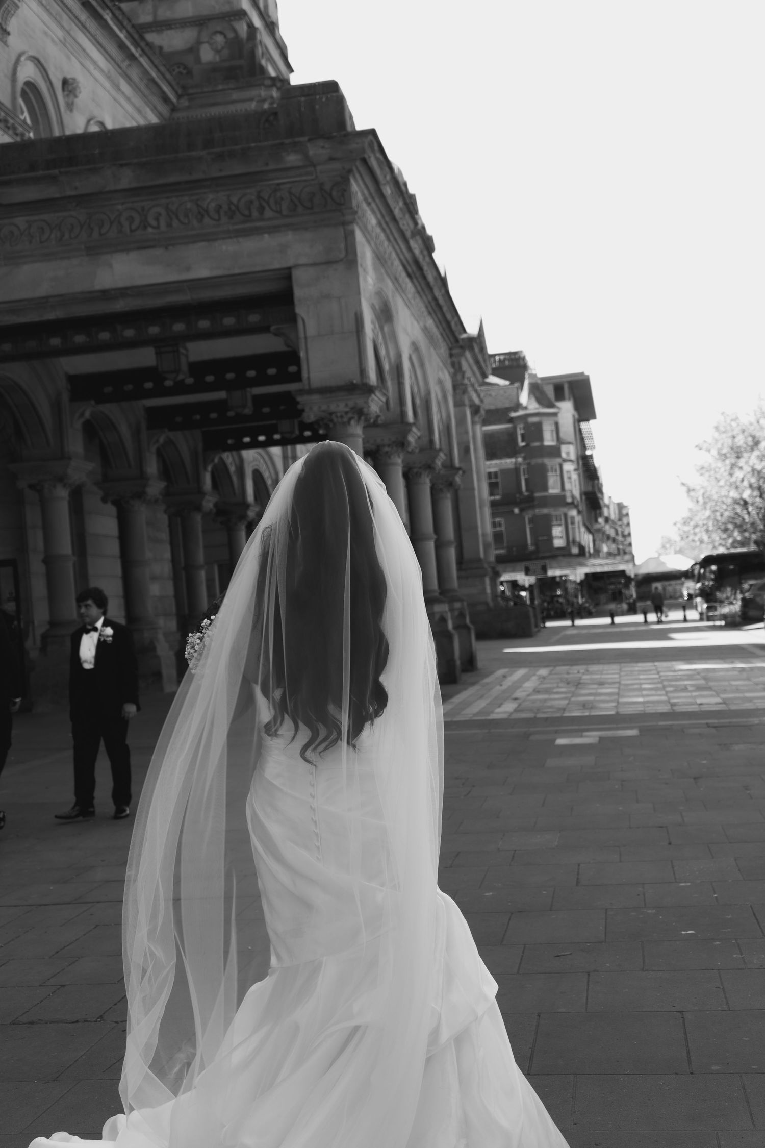 Bride walking towards her ceremony in a timeless black and white wedding portrait, captured by luxury wedding content creator Unveil by Holl