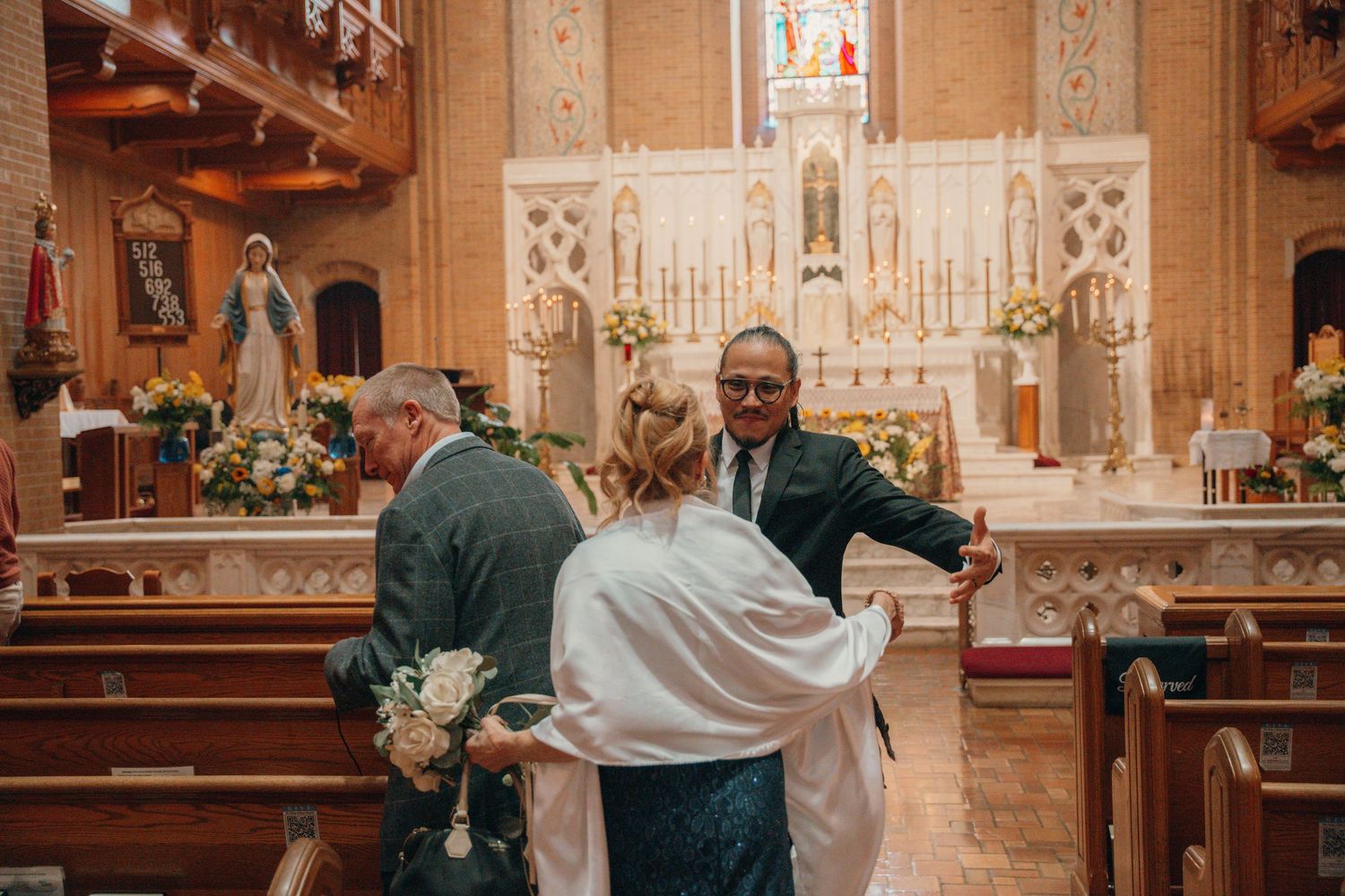 Bride walking down the church aisle toward a white marble high altar