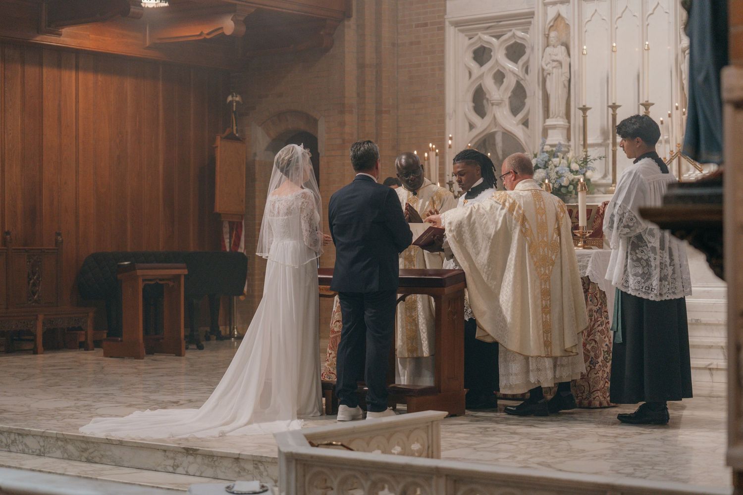Bride and groom receiving the nuptial blessing at a Catholic wedding