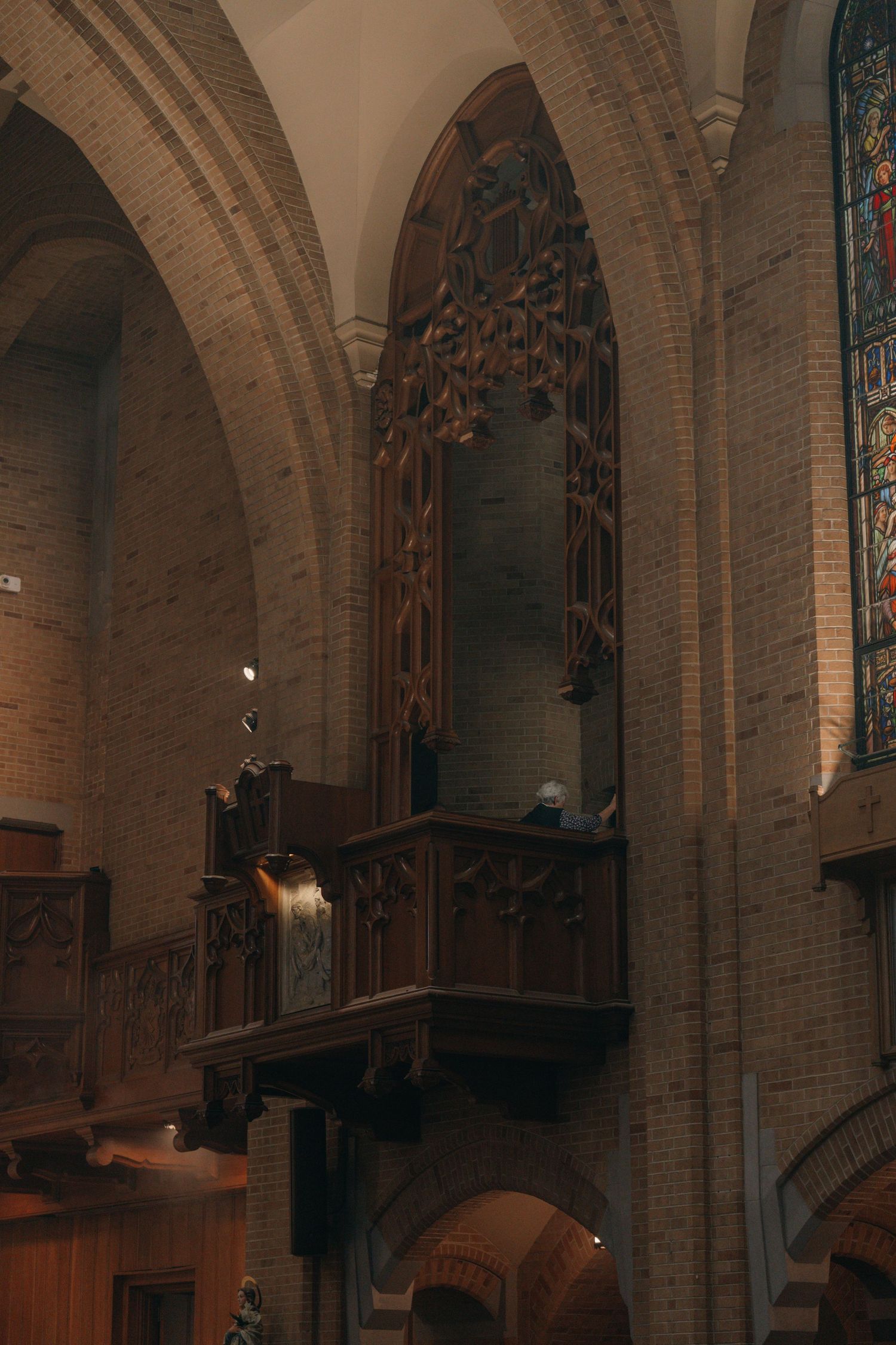 Interior of a Gothic church with carved wooden arches and stained glass