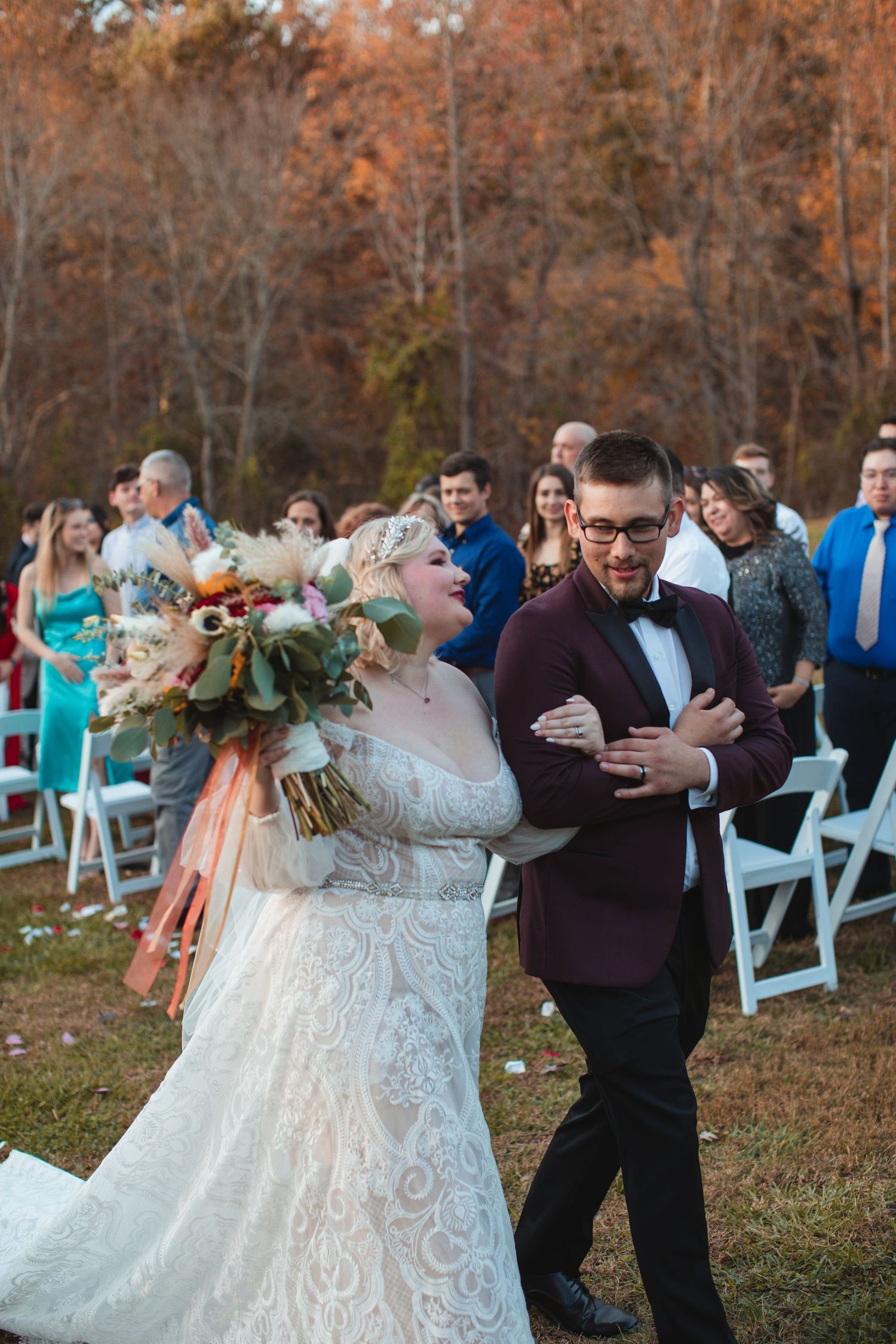 Bride walking down the aisle with her bouquet at an outdoor autumn ceremony