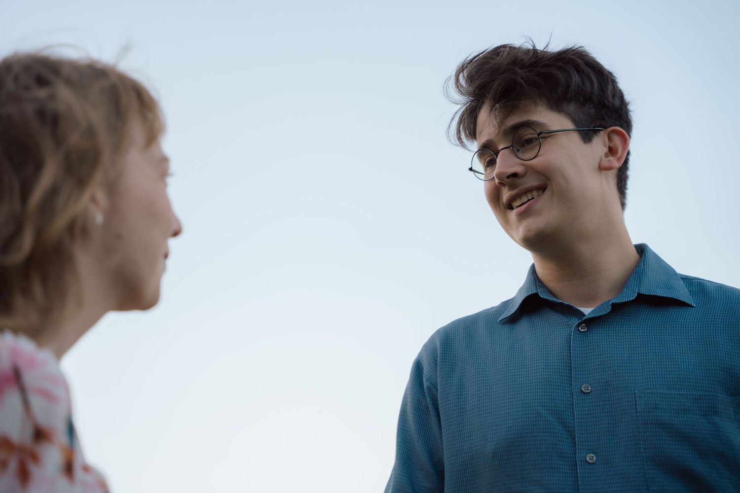 Couple smiling at each other against a clear evening sky