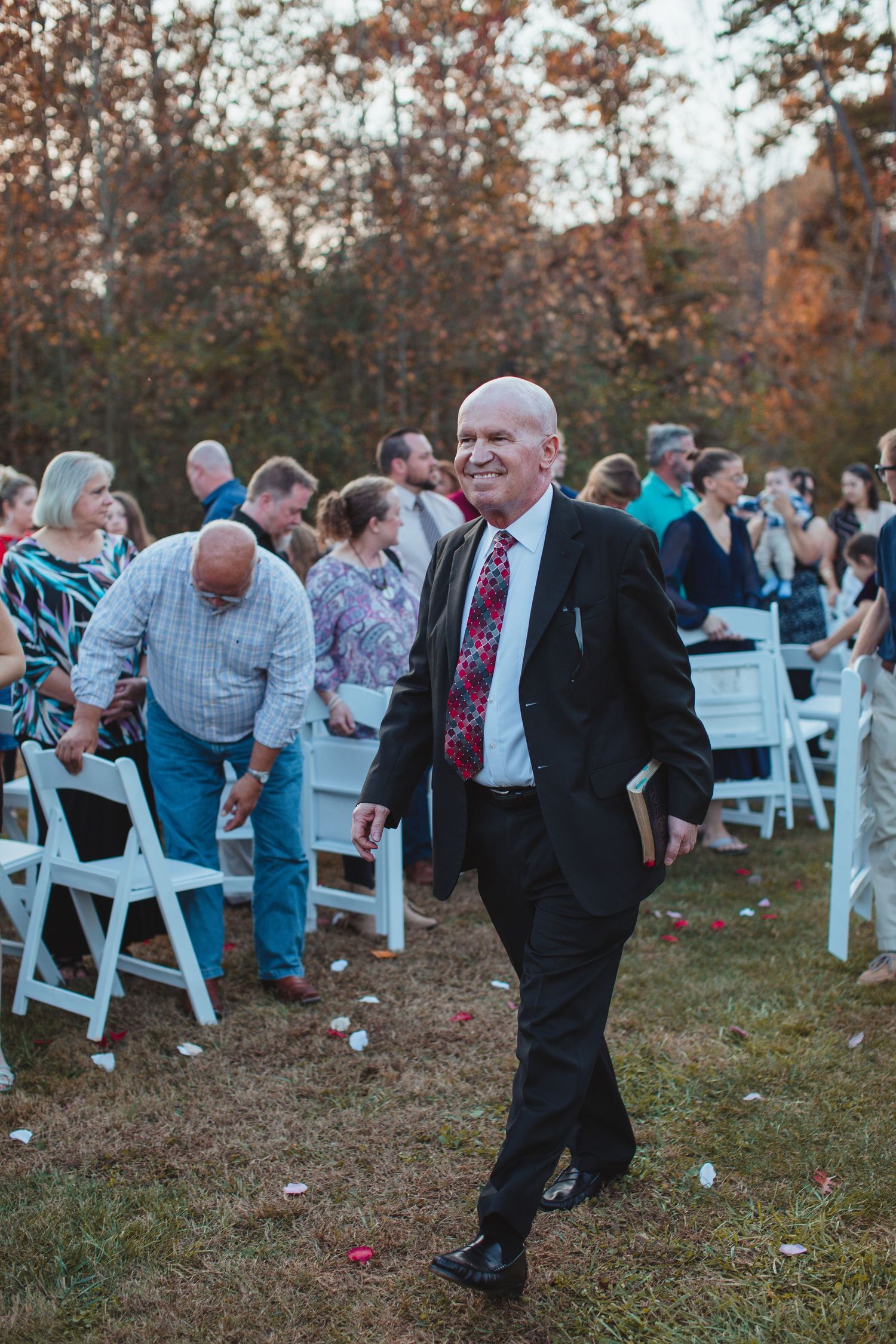 Father of the bride walking down the aisle at an outdoor fall wedding