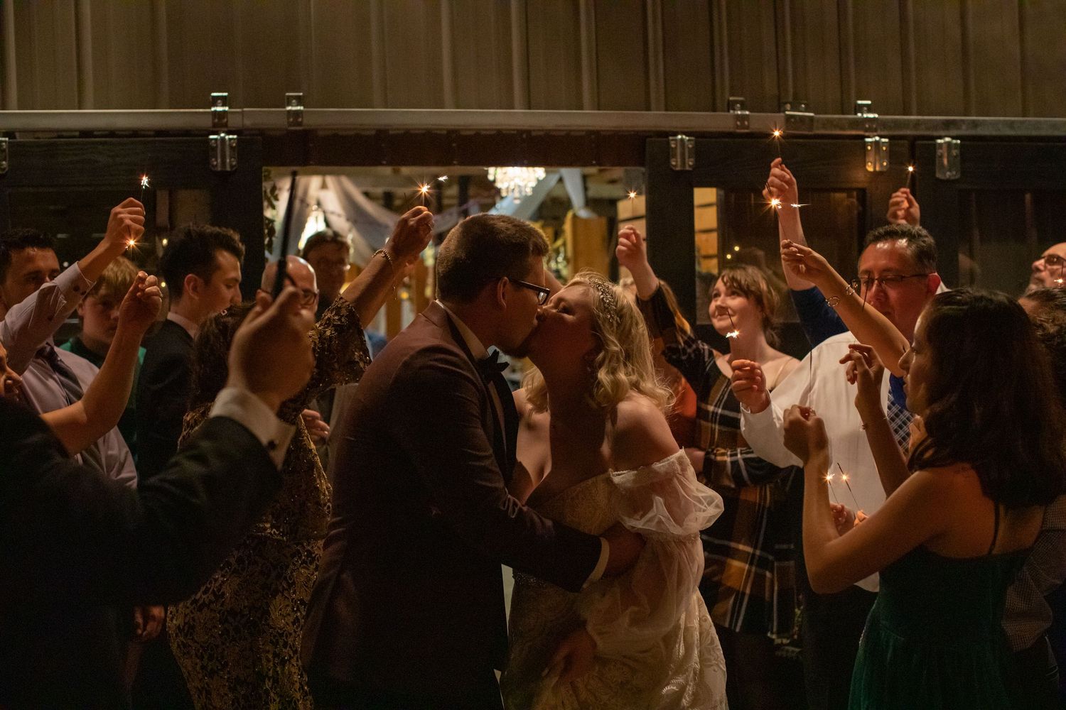Wedding guests celebrating on a crowded dance floor at a barn reception