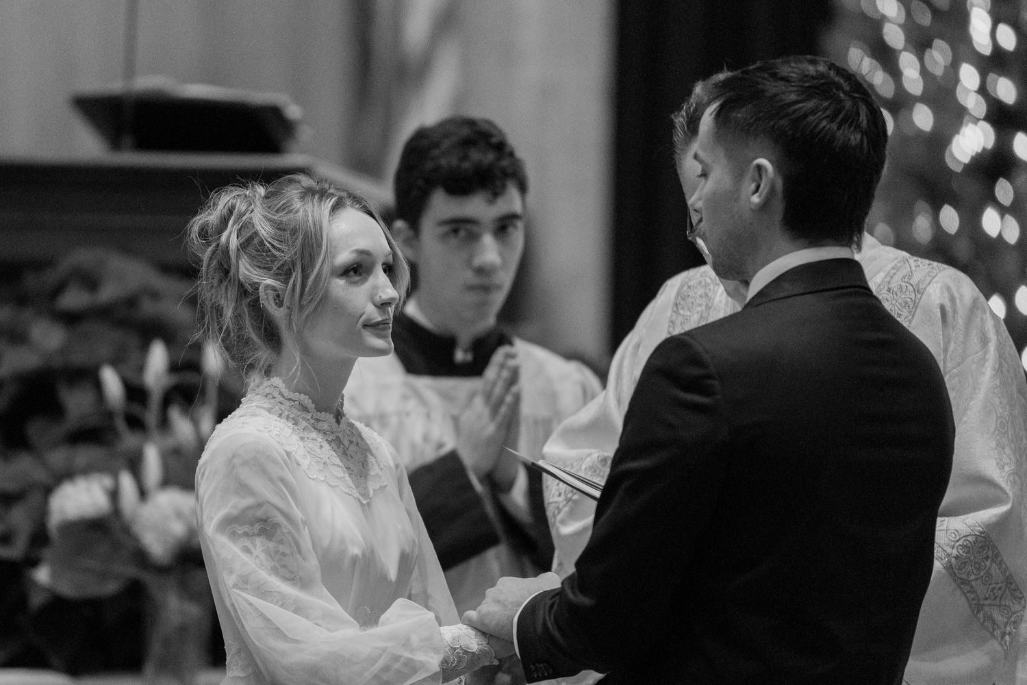 Black and white photo of the exchange of vows at a Catholic wedding