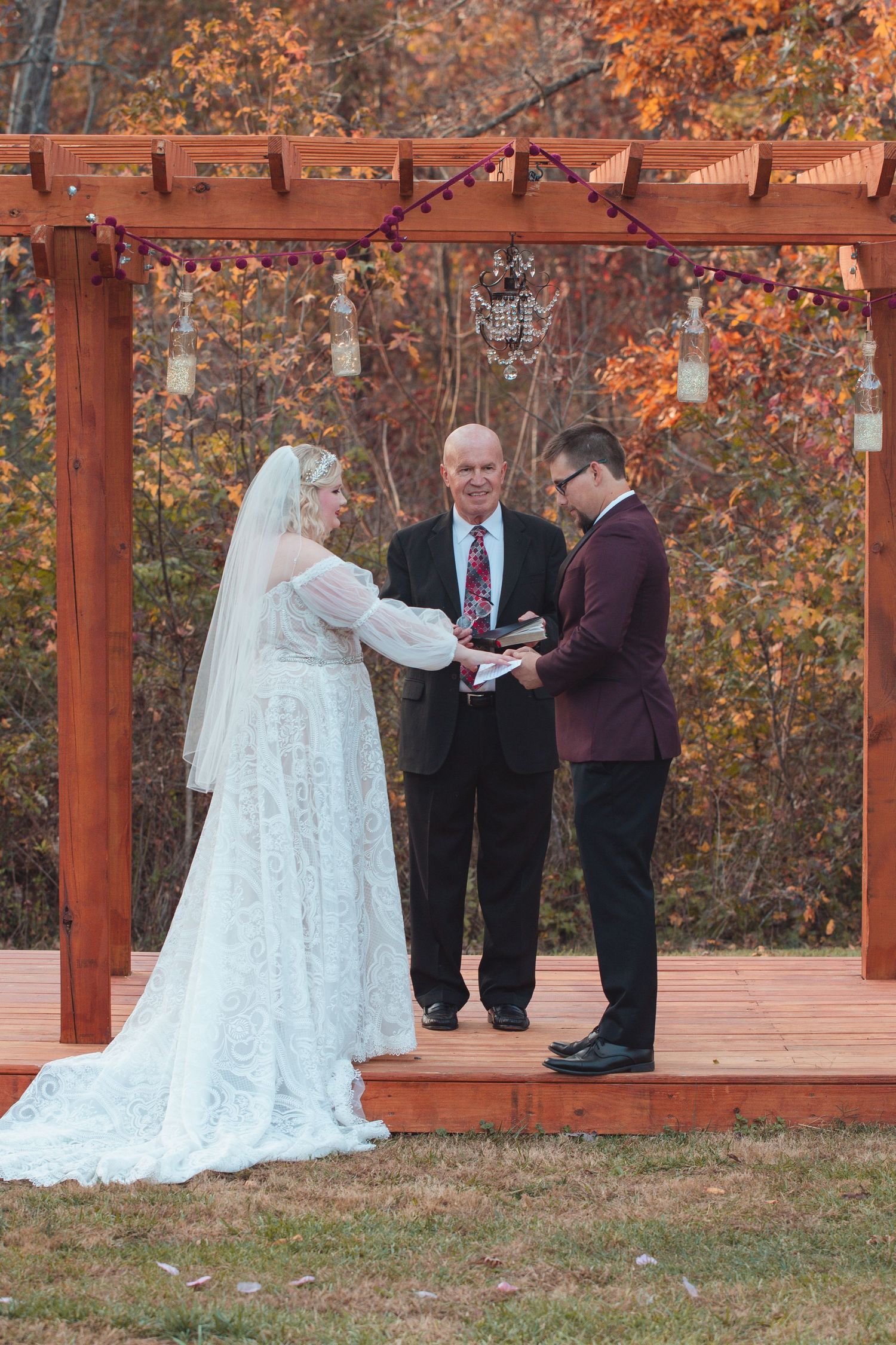 Officiant leading the bride and groom through their vows under a pergola