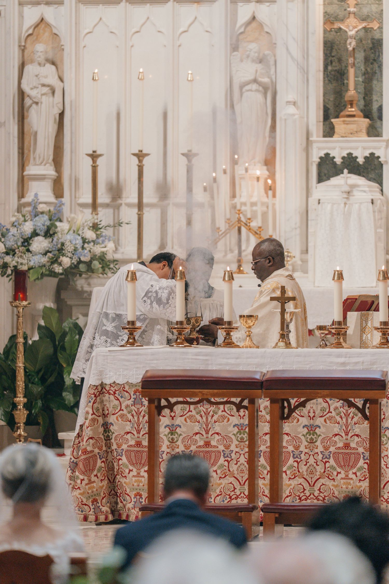 Priest celebrating Mass at an ornate marble high altar during a wedding