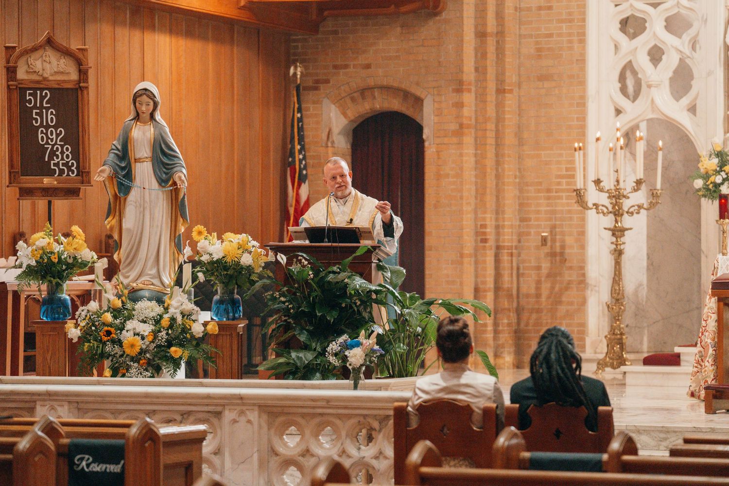 Marian shrine with flowers and candles beside the altar in a Catholic church