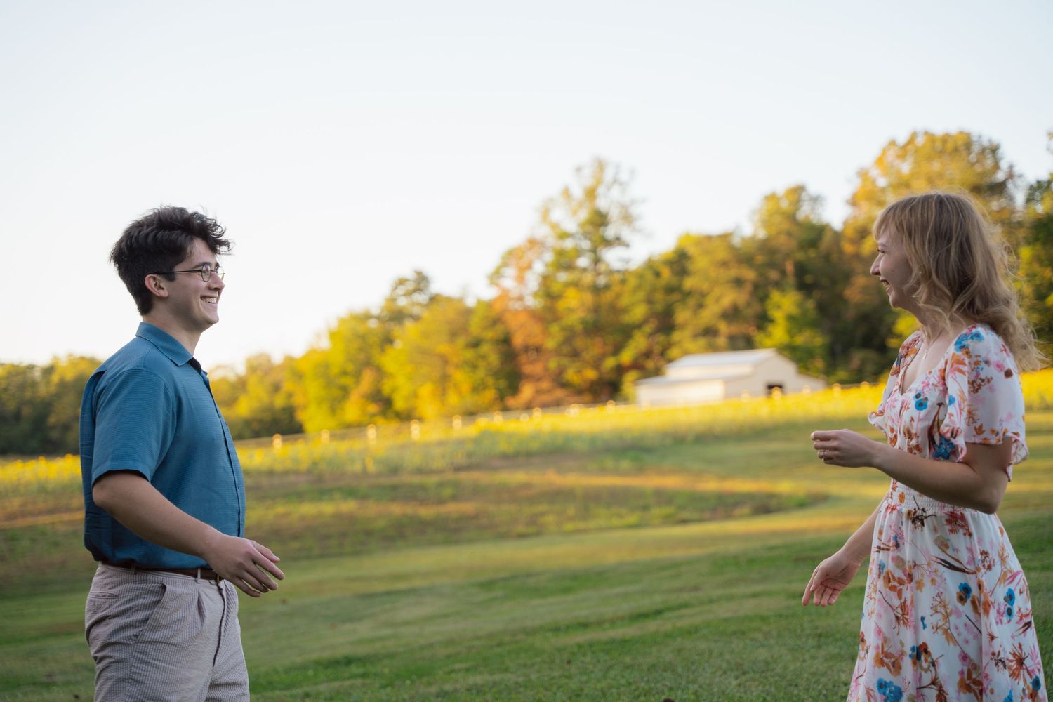 Couple walking toward each other across a sunlit meadow